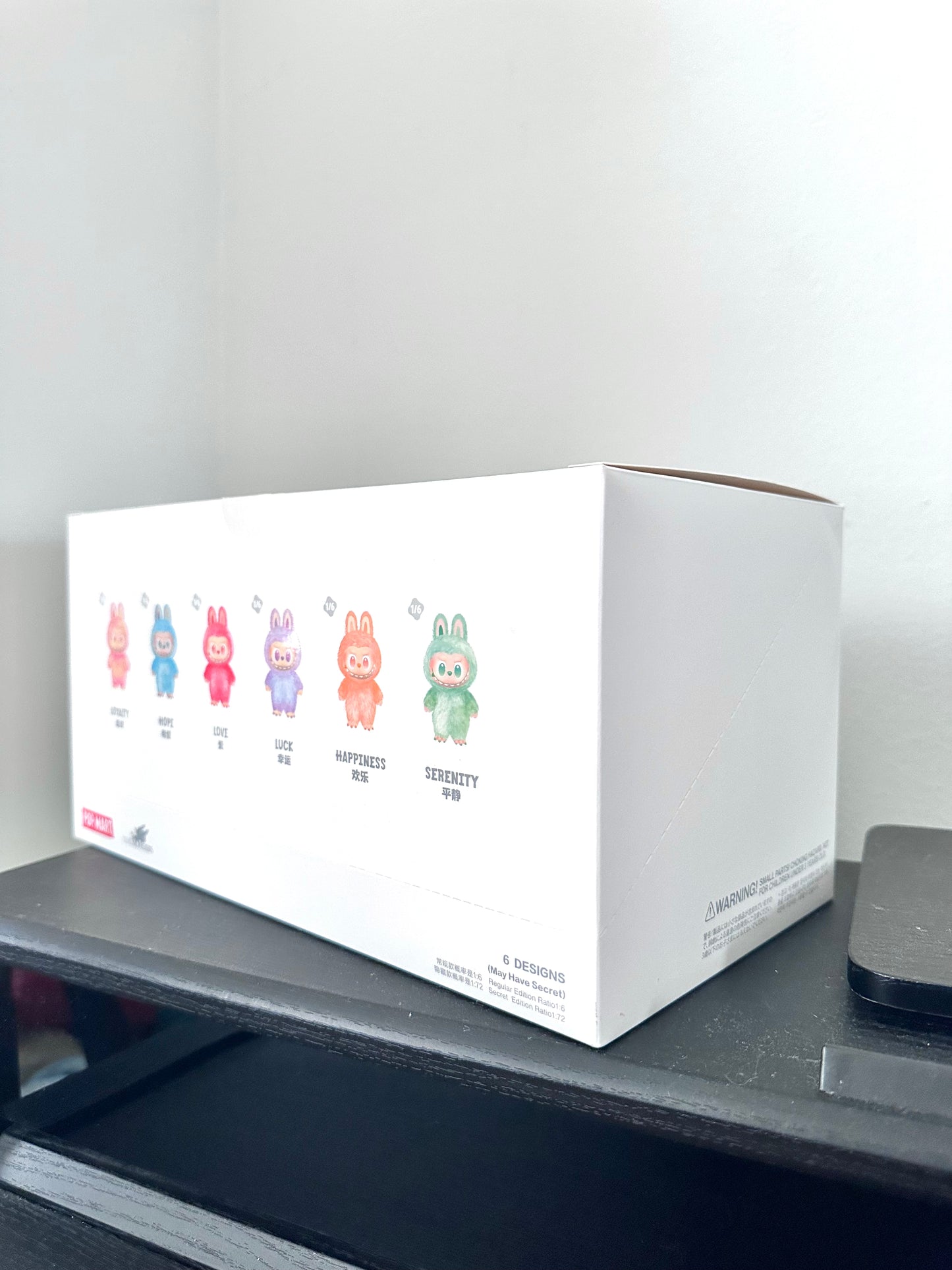 White box with colorful illustrations on a gray surface