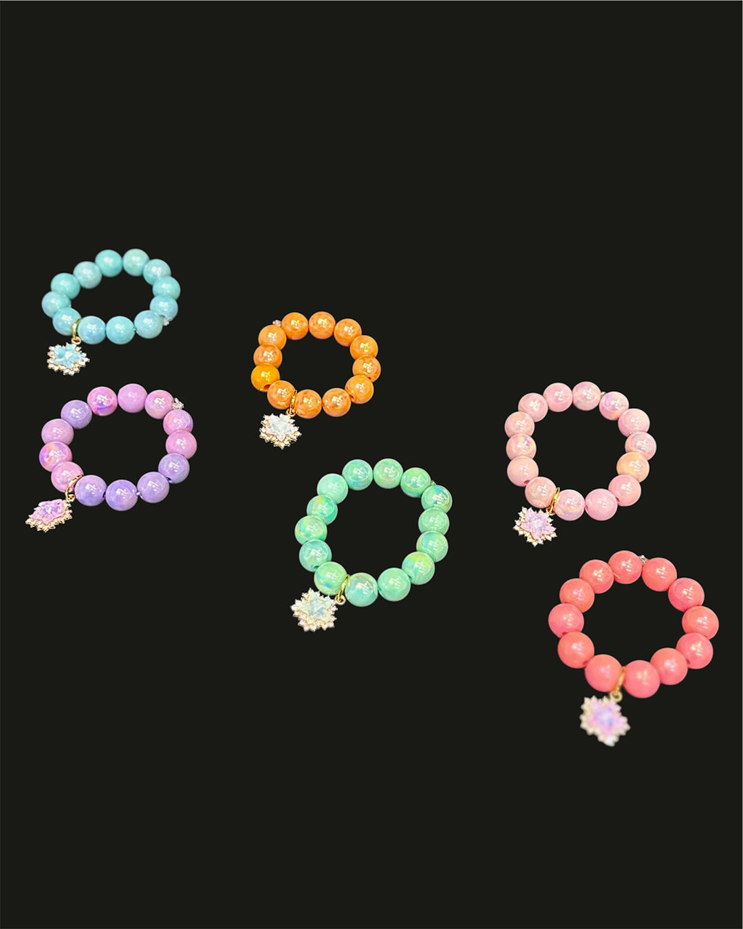 Set of colorful beaded bracelets with floral charms on a black background