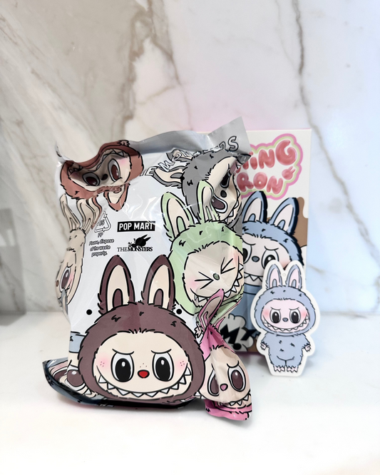 Collection of cartoon character plush toys on a white surface with a blurred background