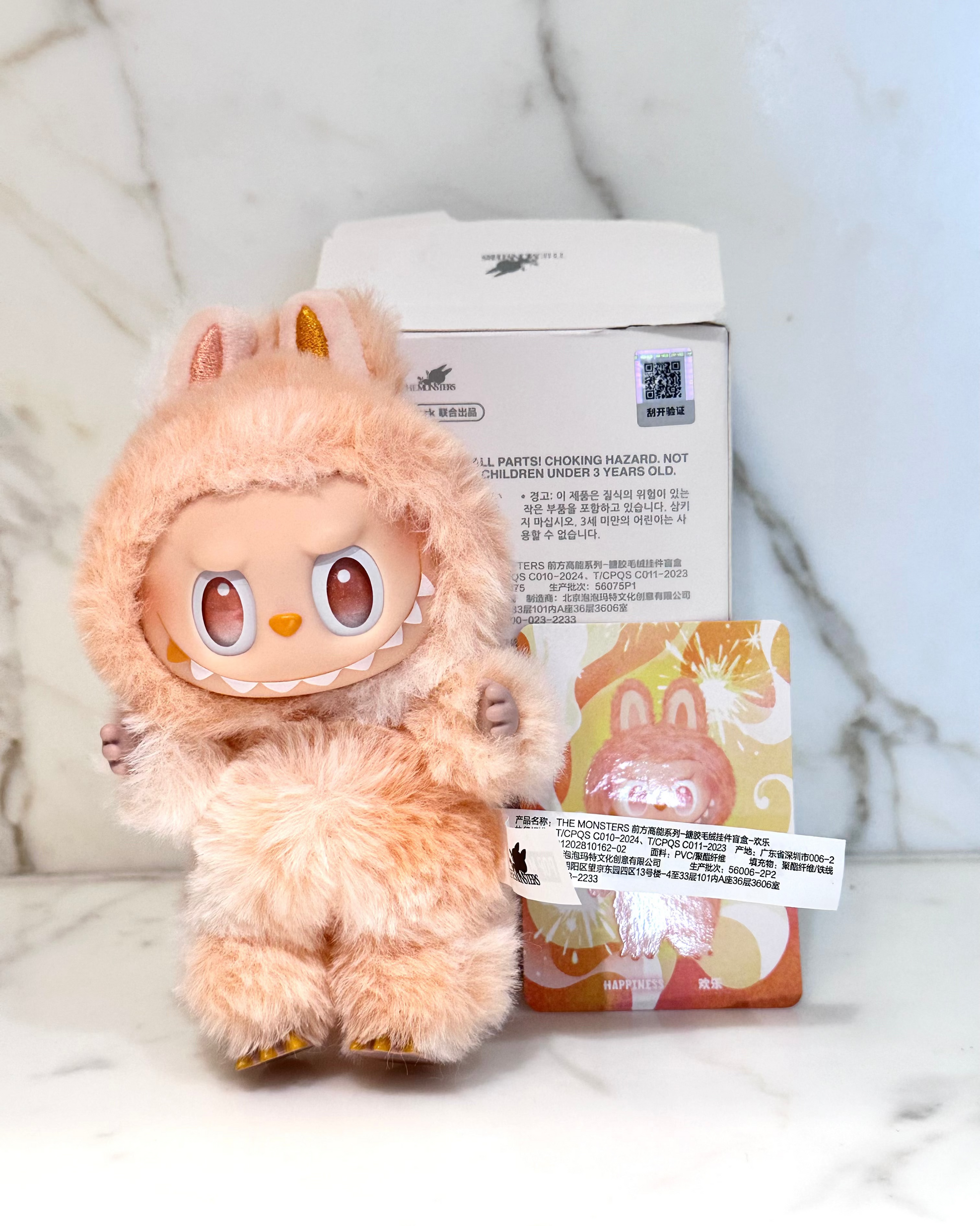 Plush toy with a packaging box on a marble surface