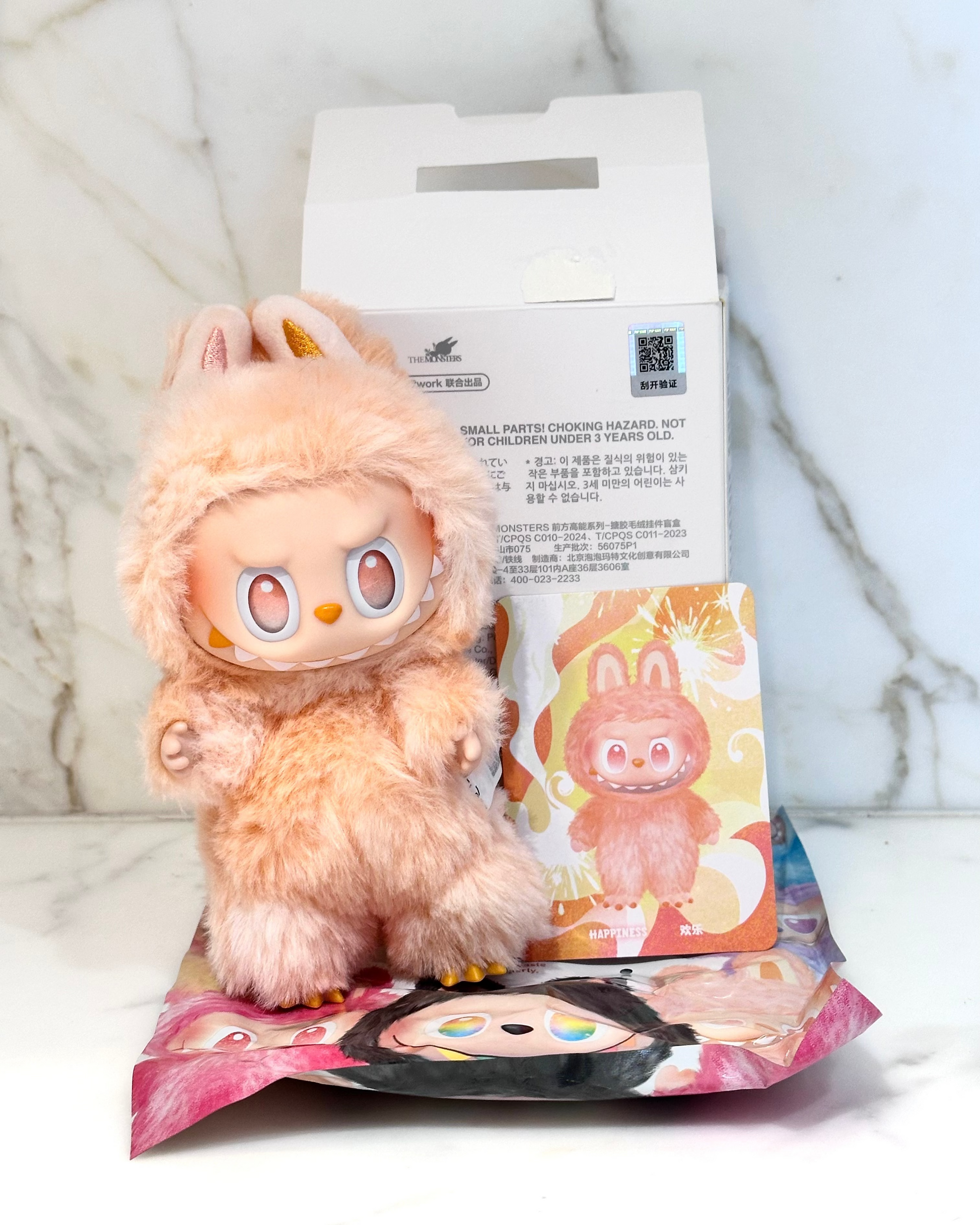 Plush toy with packaging on a marble surface