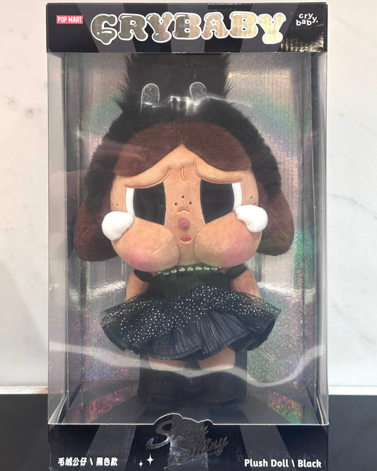 Plush doll in packaging with 'Crybaby' branding on a white background