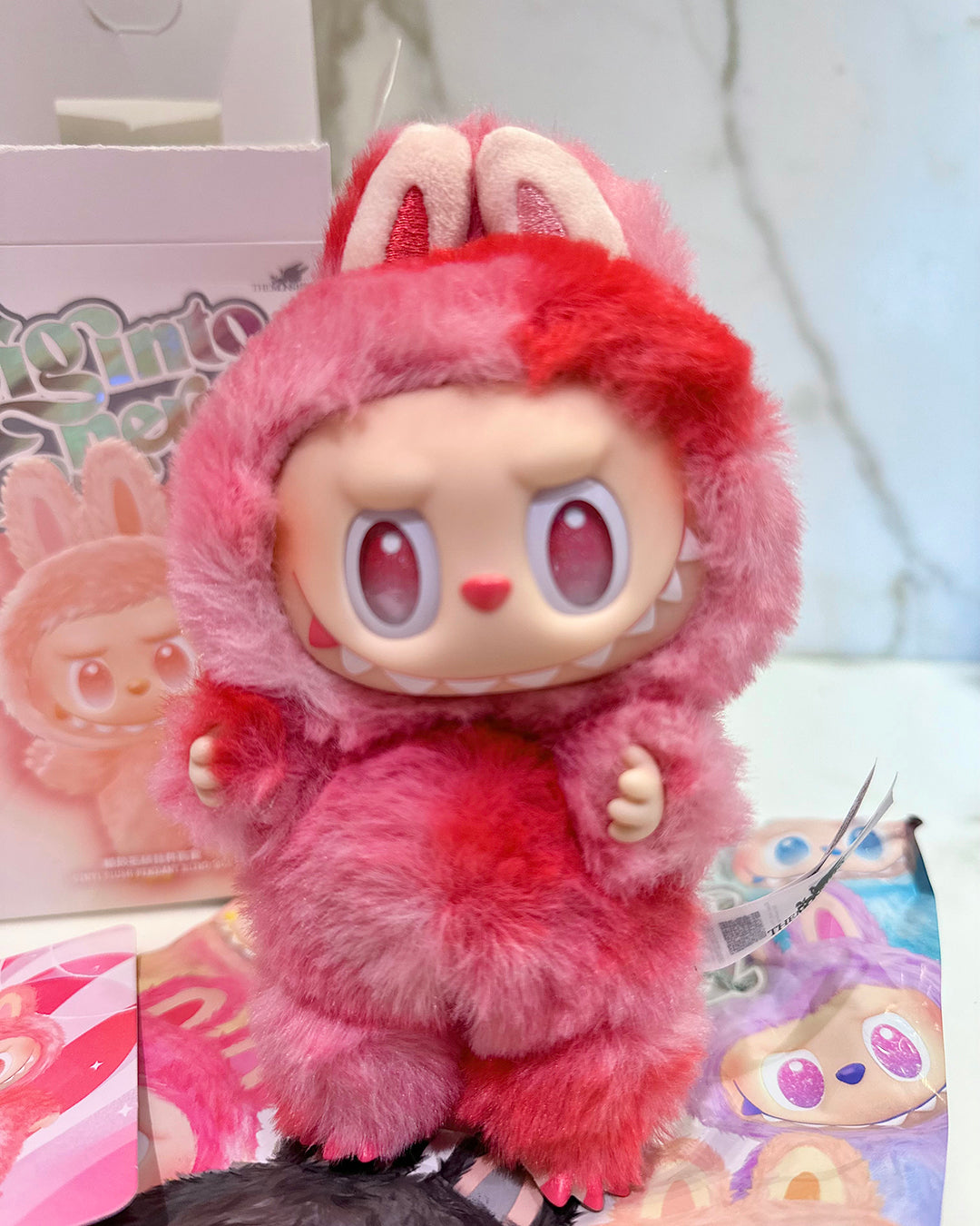 Pink plush toy with bunny ears on a colorful background