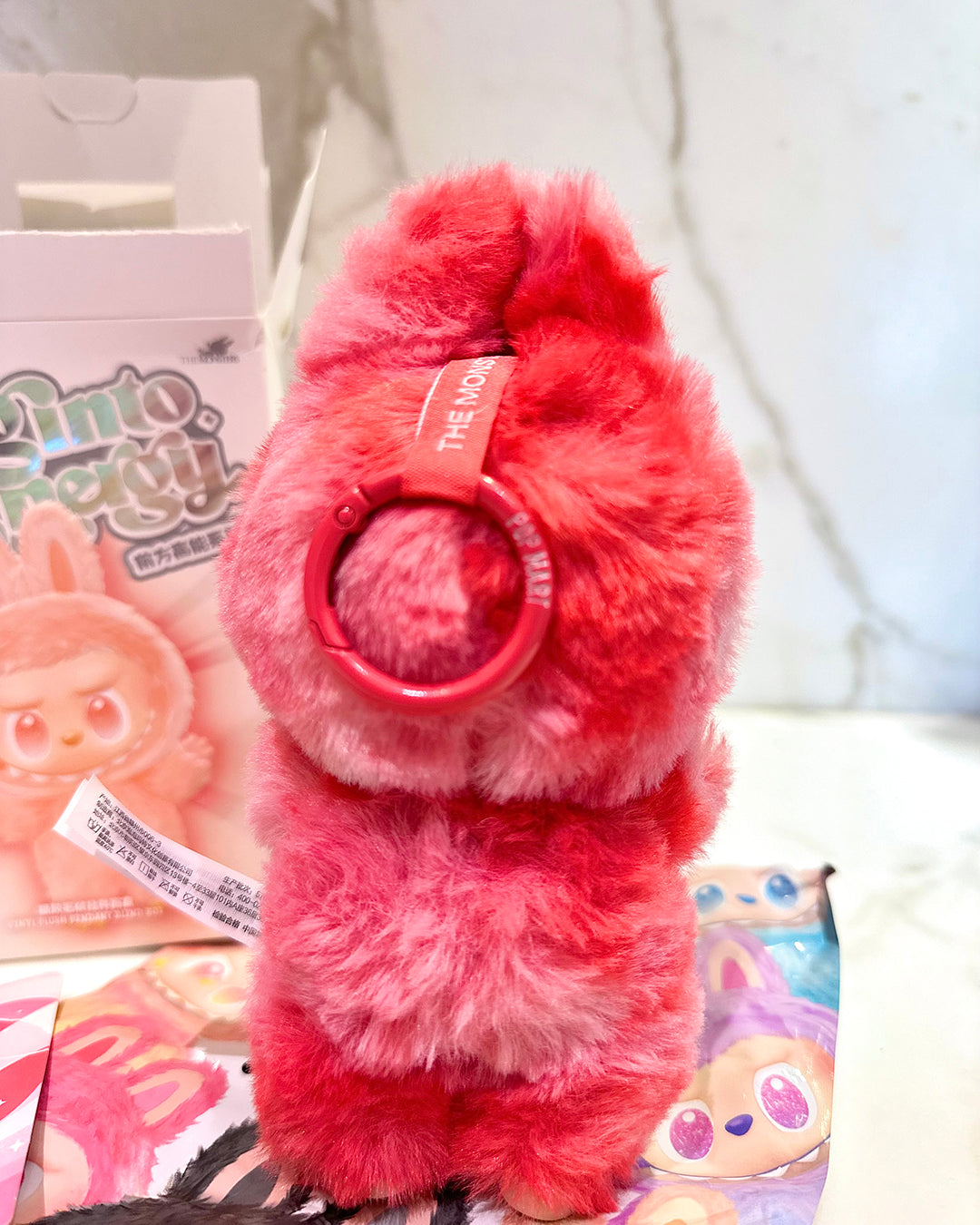 Red plush toy with a headband on a colorful background