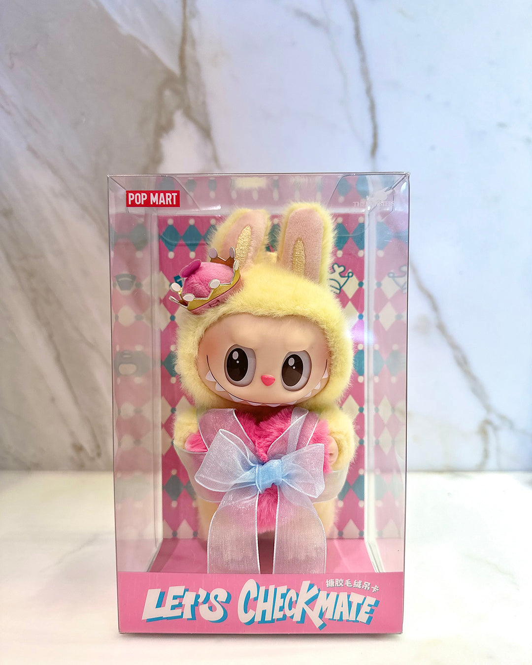 Toy figure in a bunny costume with a pink bow in clear packaging, featuring the brand 'Pop Mart'.