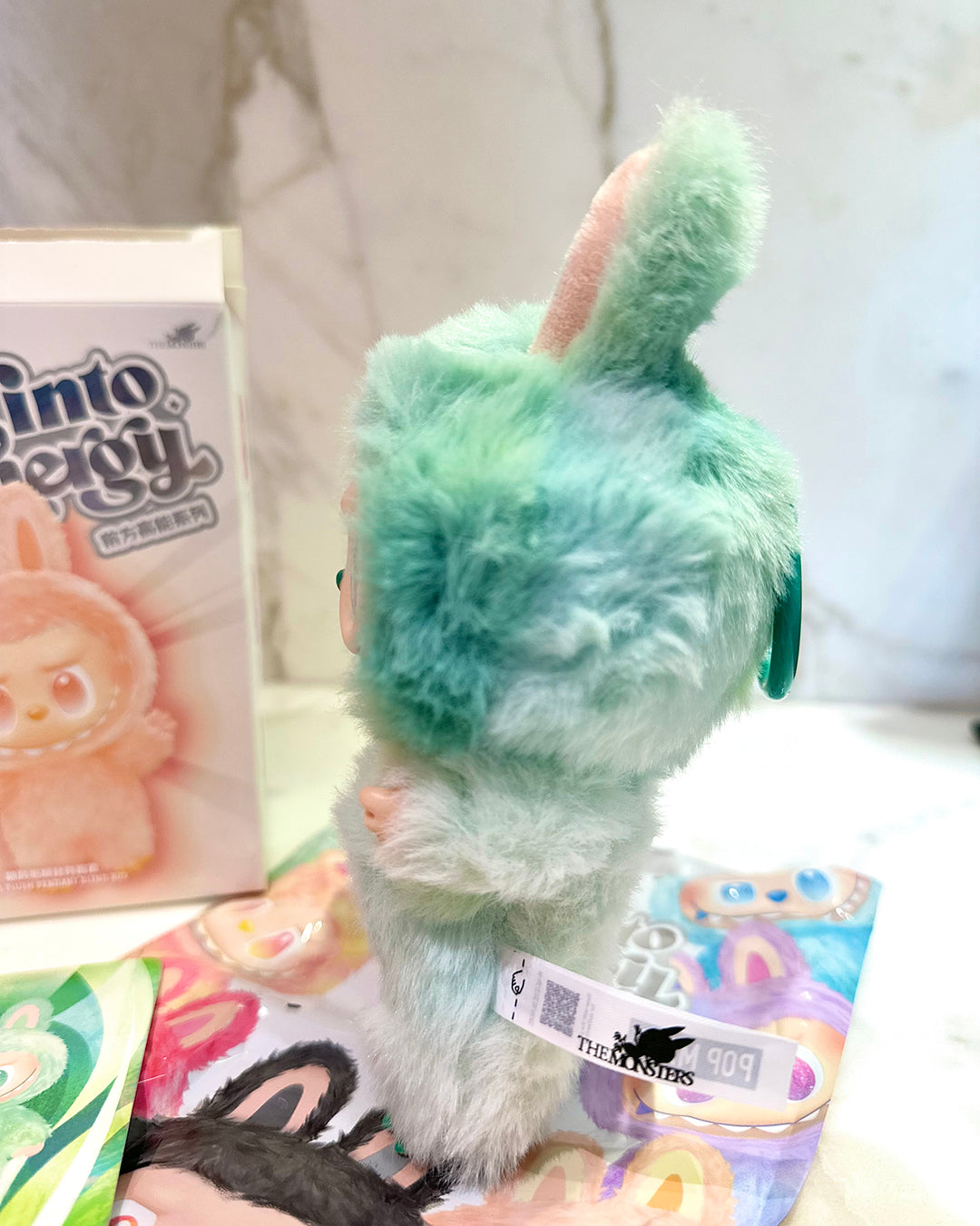 Green plush toy with a label on a white surface