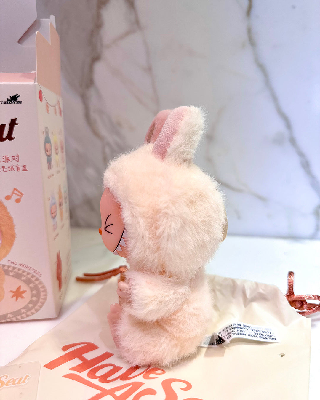 Small plush toy with bunny ears on a white surface