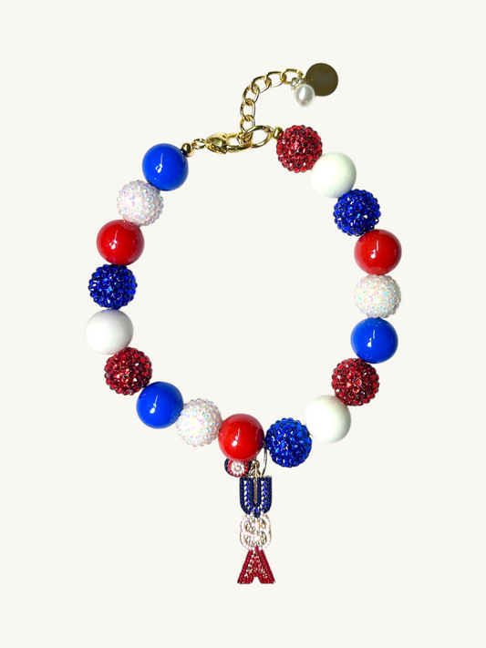A pet luxury beaded necklace handmade in New York City in red, white, and blue with USA initial charm as part of The Haus Royale's The Americana collection