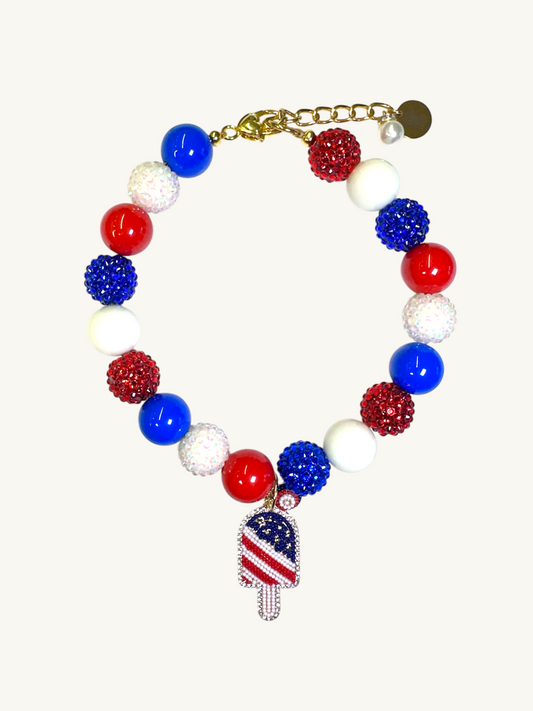 A pet luxury beaded necklace handmade in New York City in red, white, and blue with ice cream popsicle charm as part of The Haus Royale's The Americana collection