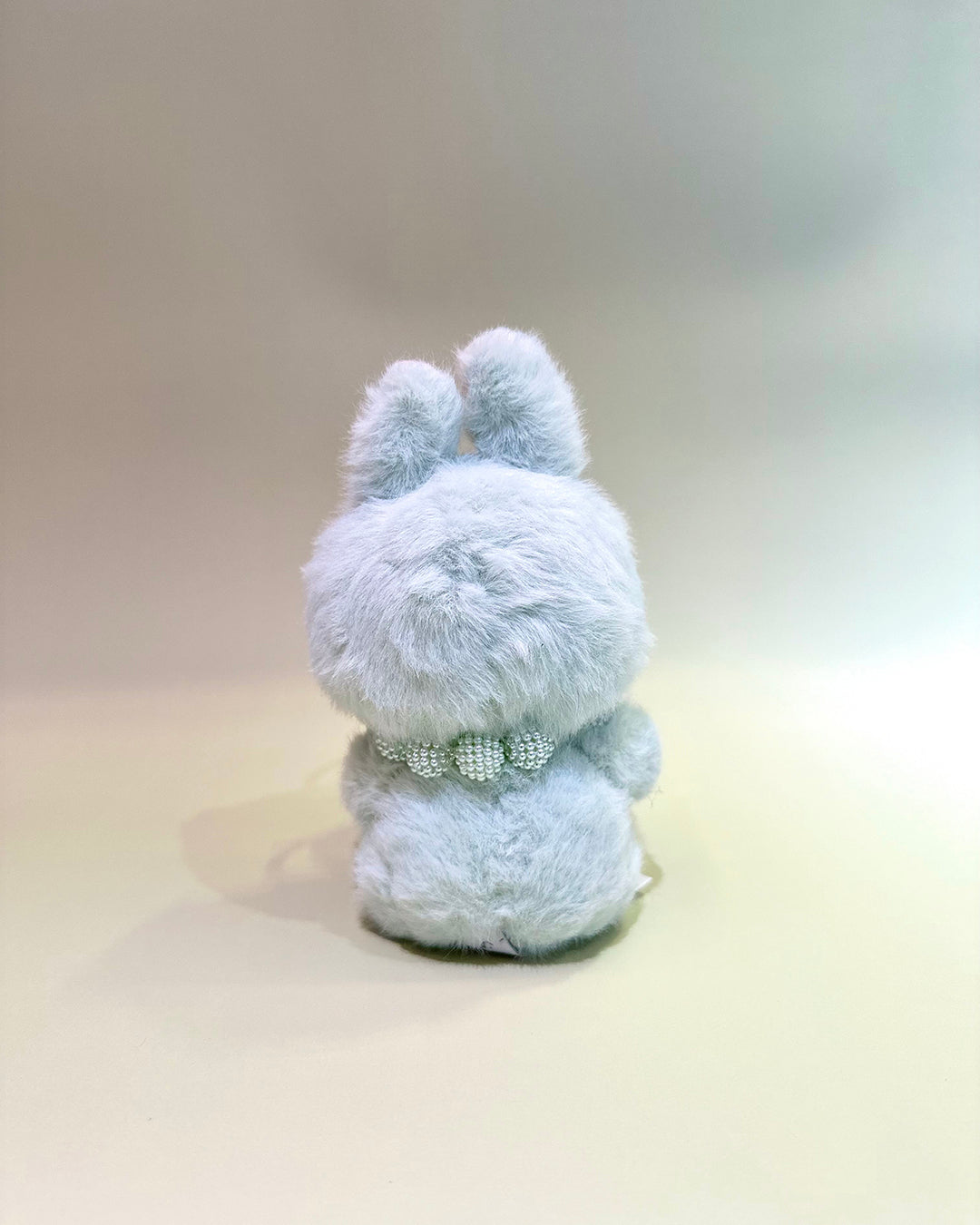 Plush toy with a bow tie on a plain background
