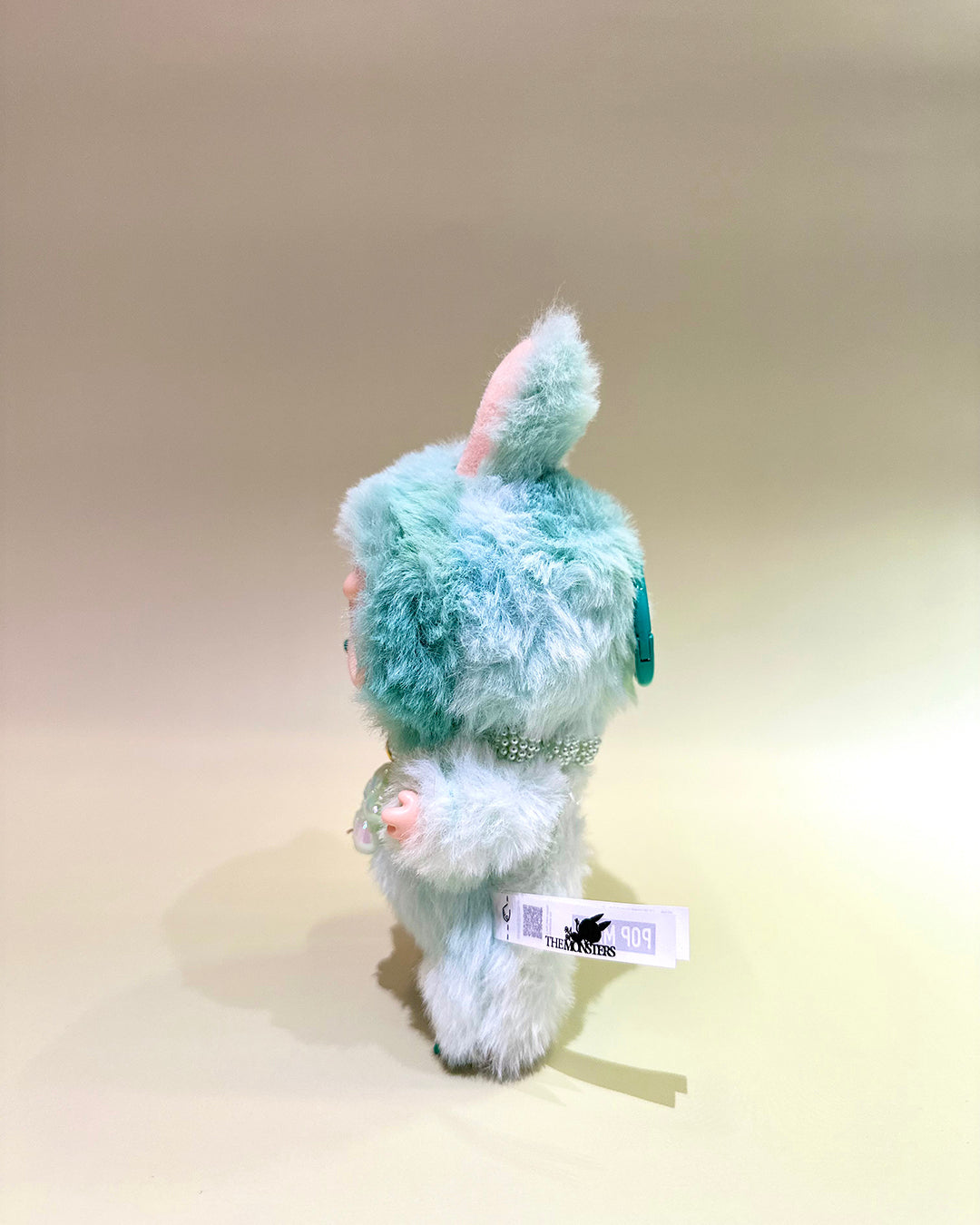 Plush toy with a tag on a beige background