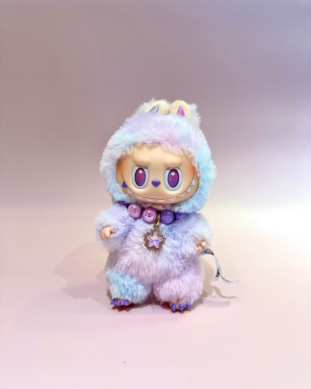 Plush toy with a unicorn design on a plain background