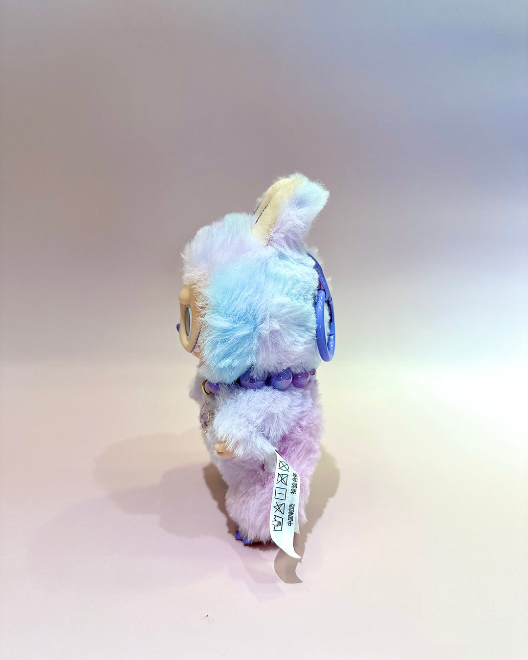 Plush toy with pastel-colored fur on a plain background