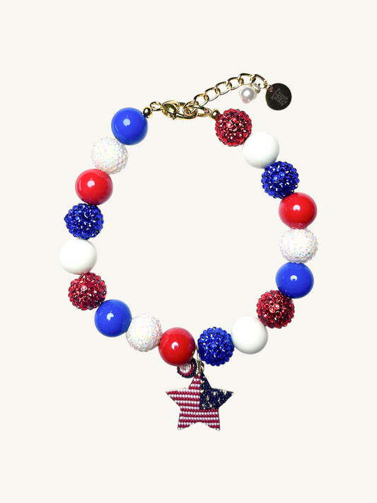 A pet luxury beaded necklace handmade in New York City in red, white, and blue with star charm as part of The Haus Royale's The Americana collection