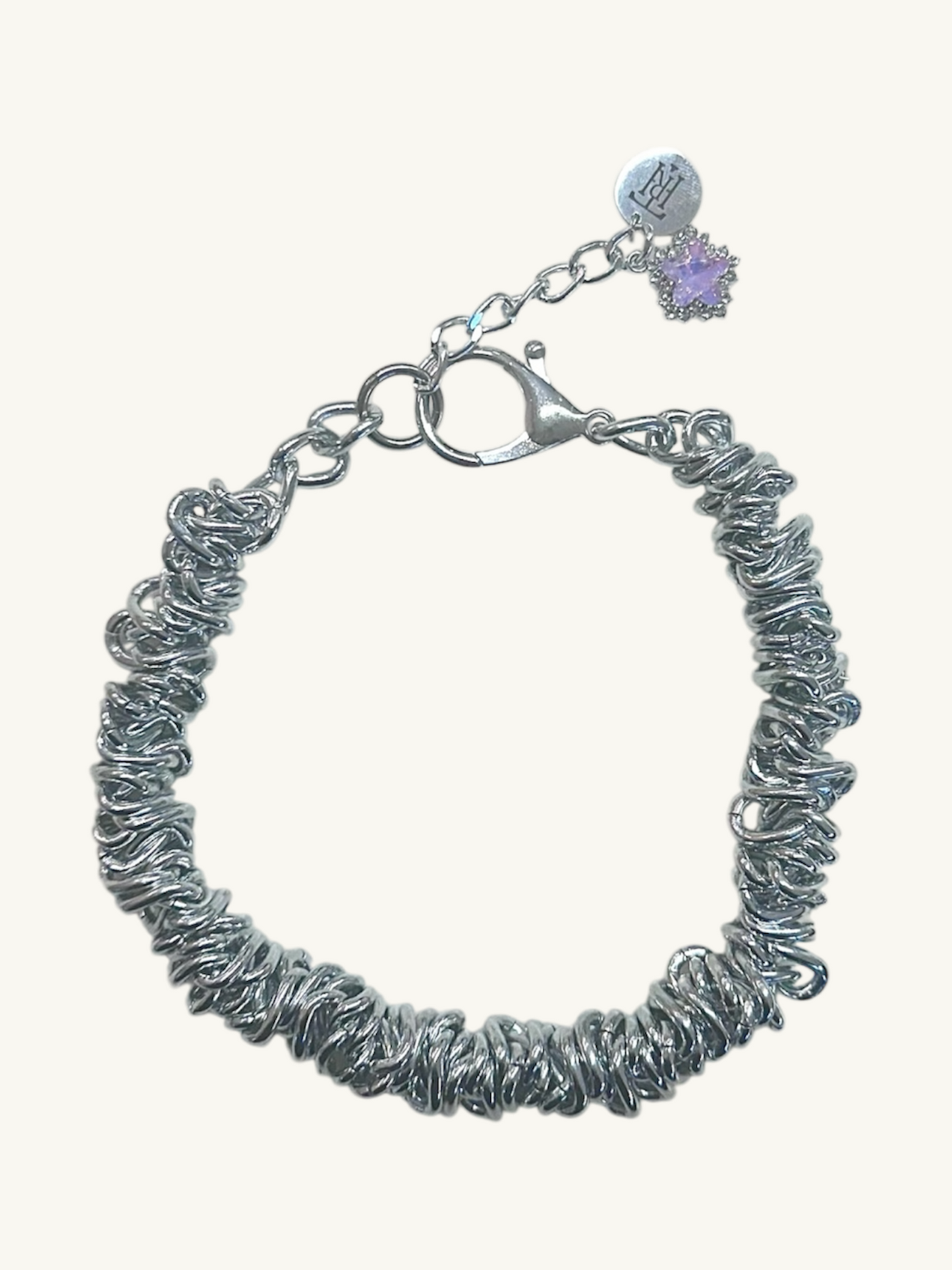 Silver textured bracelet with a purple heart charm on a white background