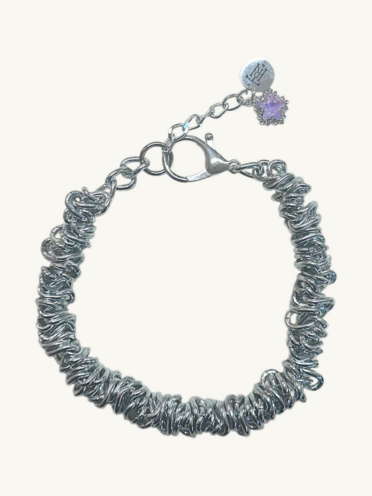Silver textured bracelet with a purple heart charm on a white background