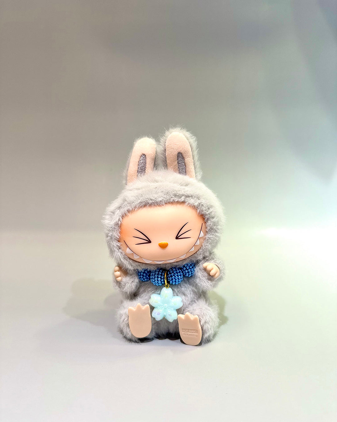 Plush toy with a rabbit costume on a light gray background