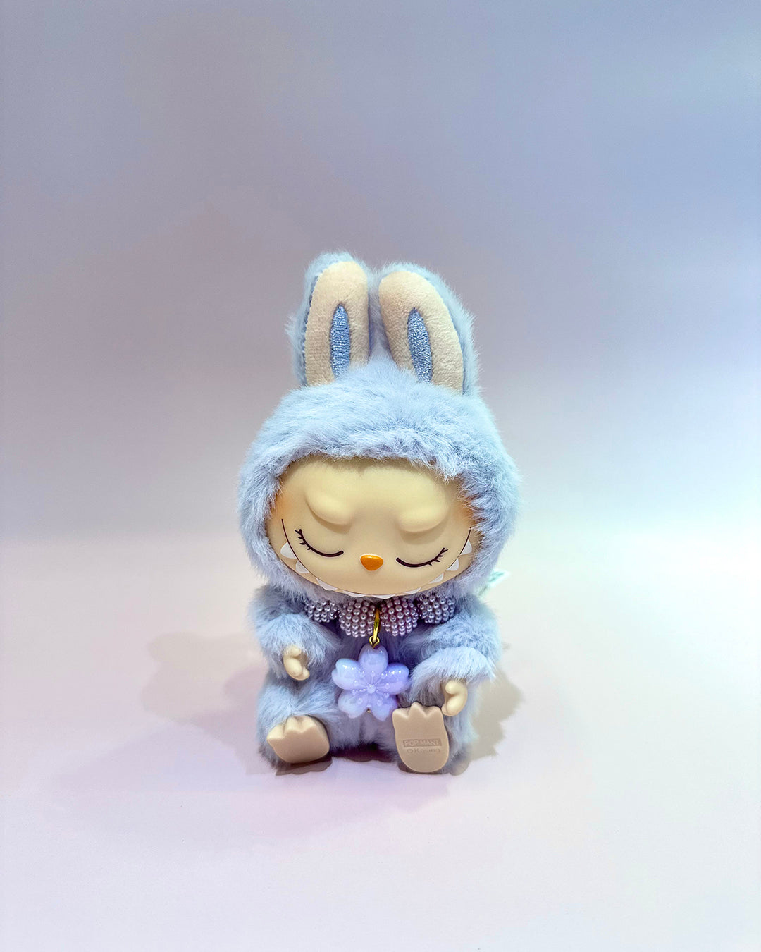 Plush toy rabbit in a blue outfit with a white background