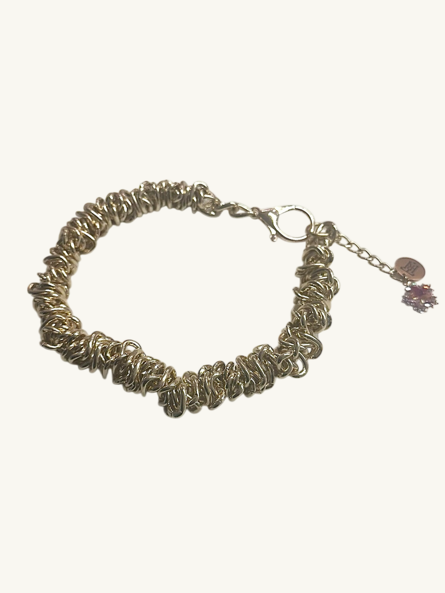 Silver bracelet with a floral charm on a white background