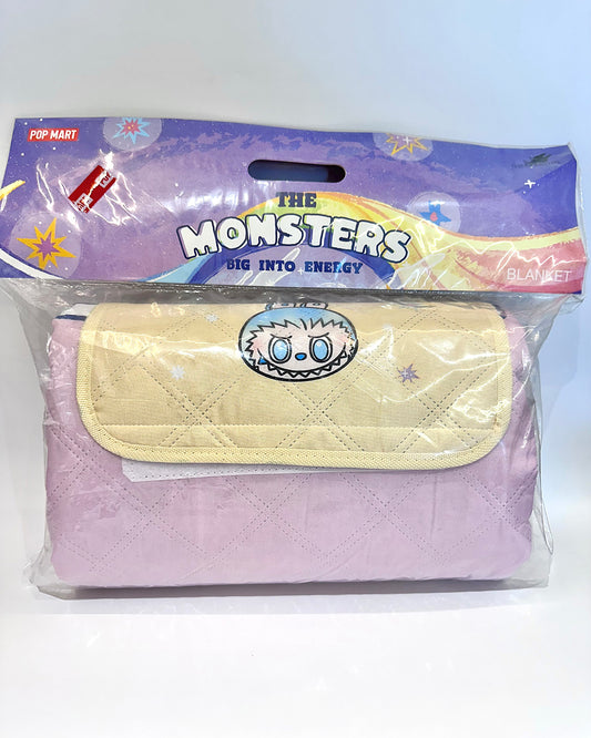 Packaged blanket with 'The Monsters' design on a white background