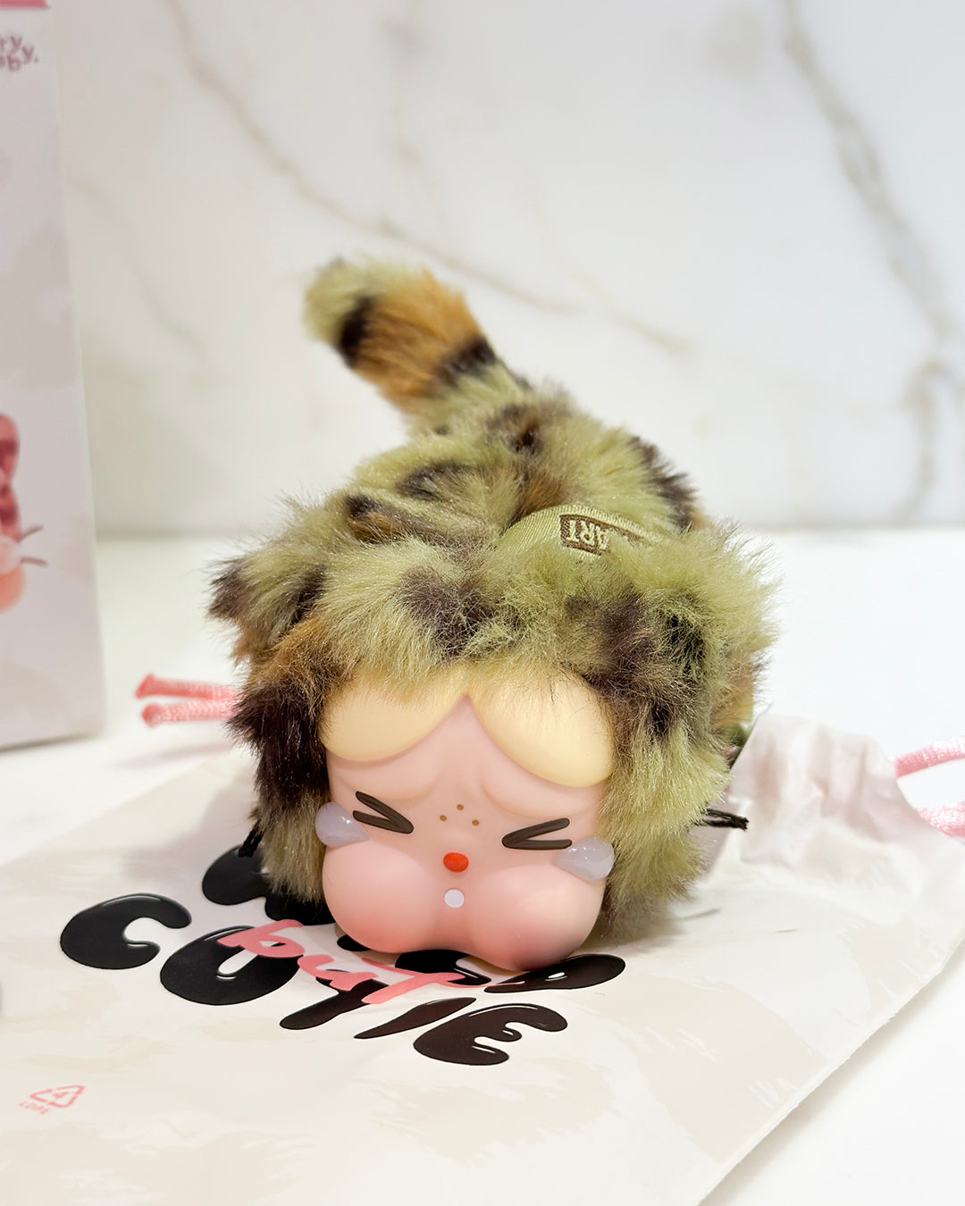 Plush toy with a leopard print hat on a white background
