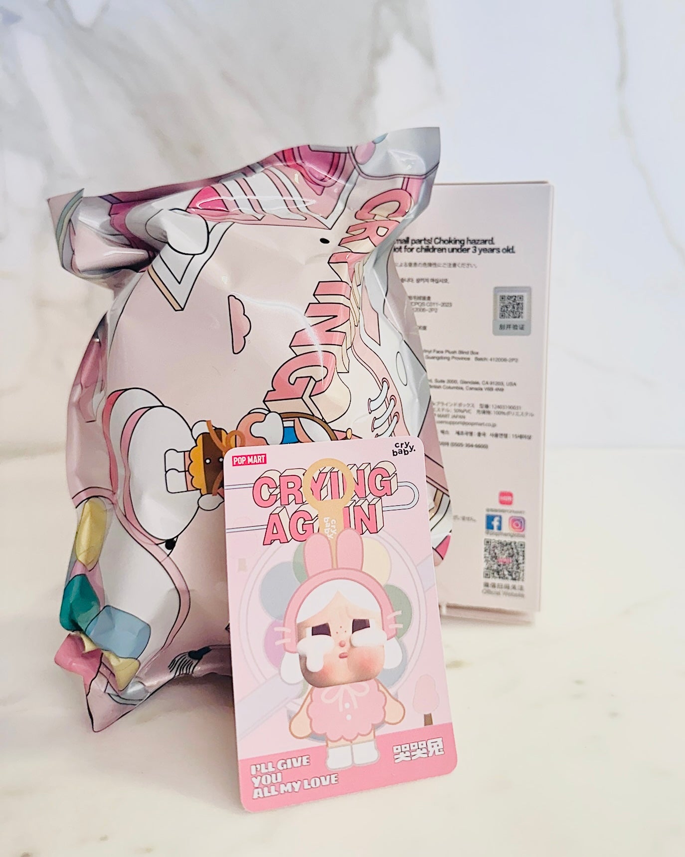 Crying Again plush toy packaging with colorful design on a white background
