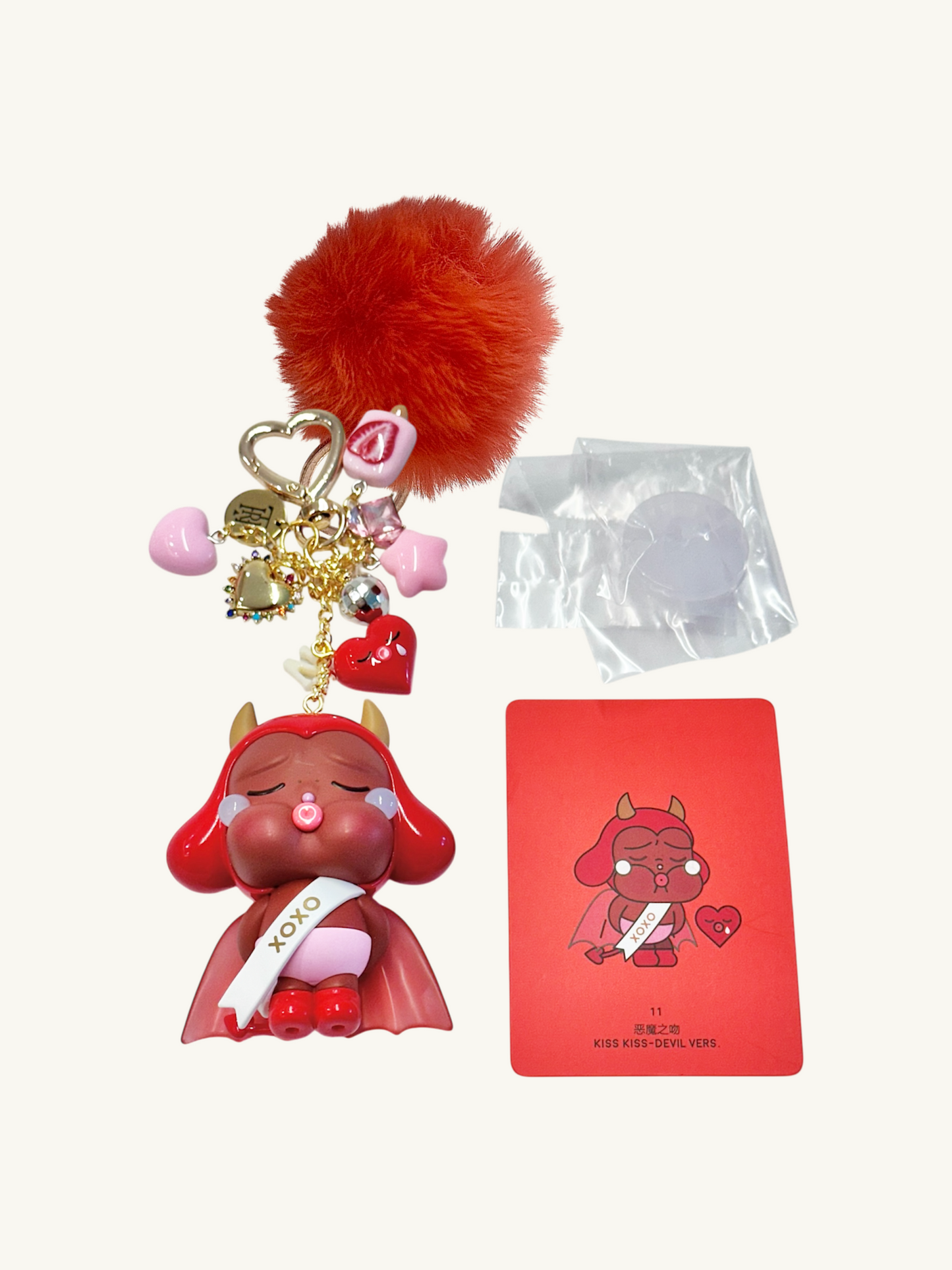 Red character keychain with accessories and a red card on a white background