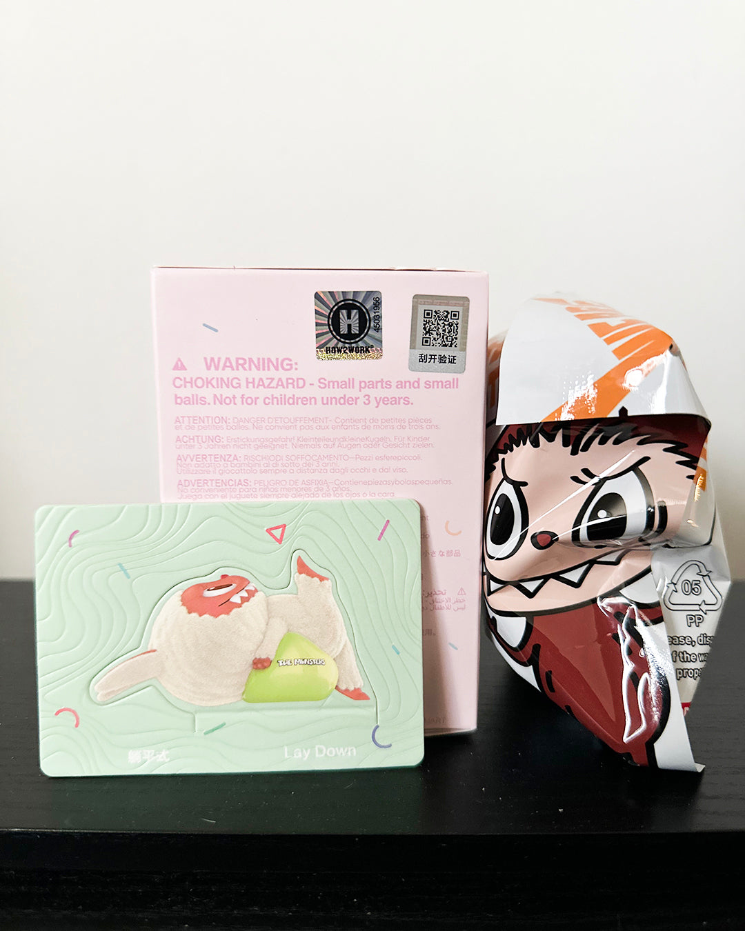 Cartoon character mask with packaging and warning label on a black surface