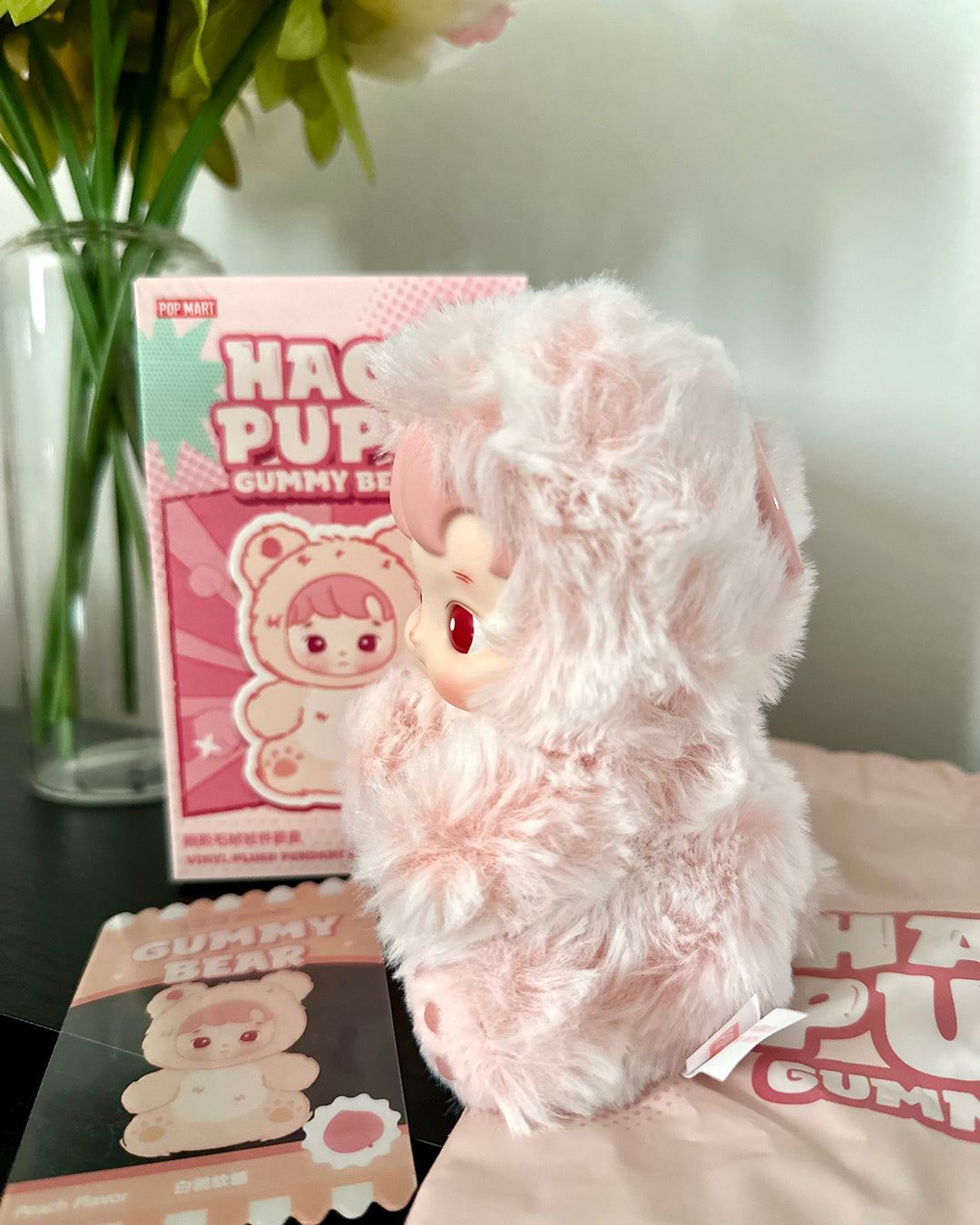 Pink plush toy with packaging on a surface