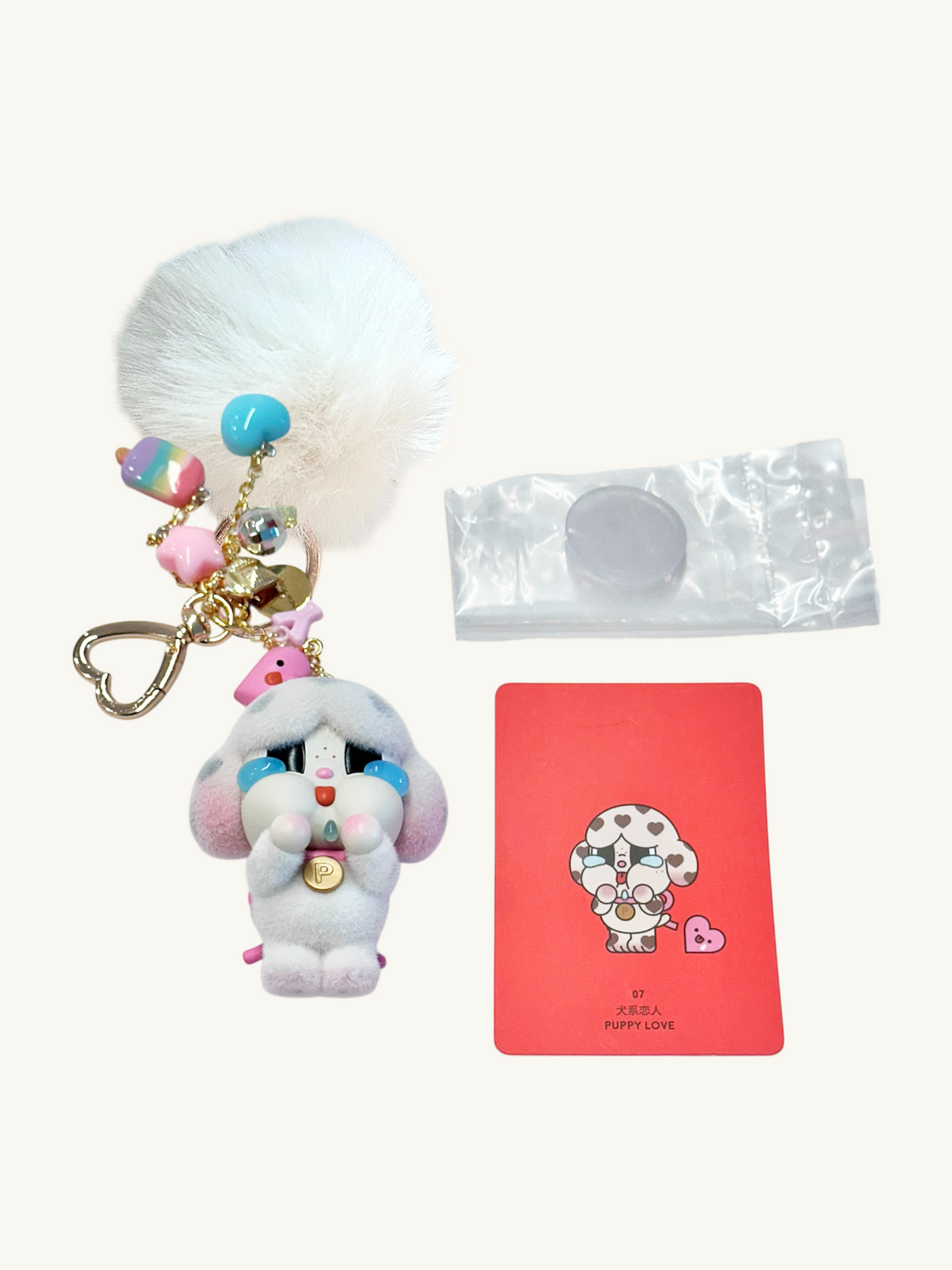 Keychain with fluffy white ball, colorful beads, and a card featuring a cartoon character on a white background.