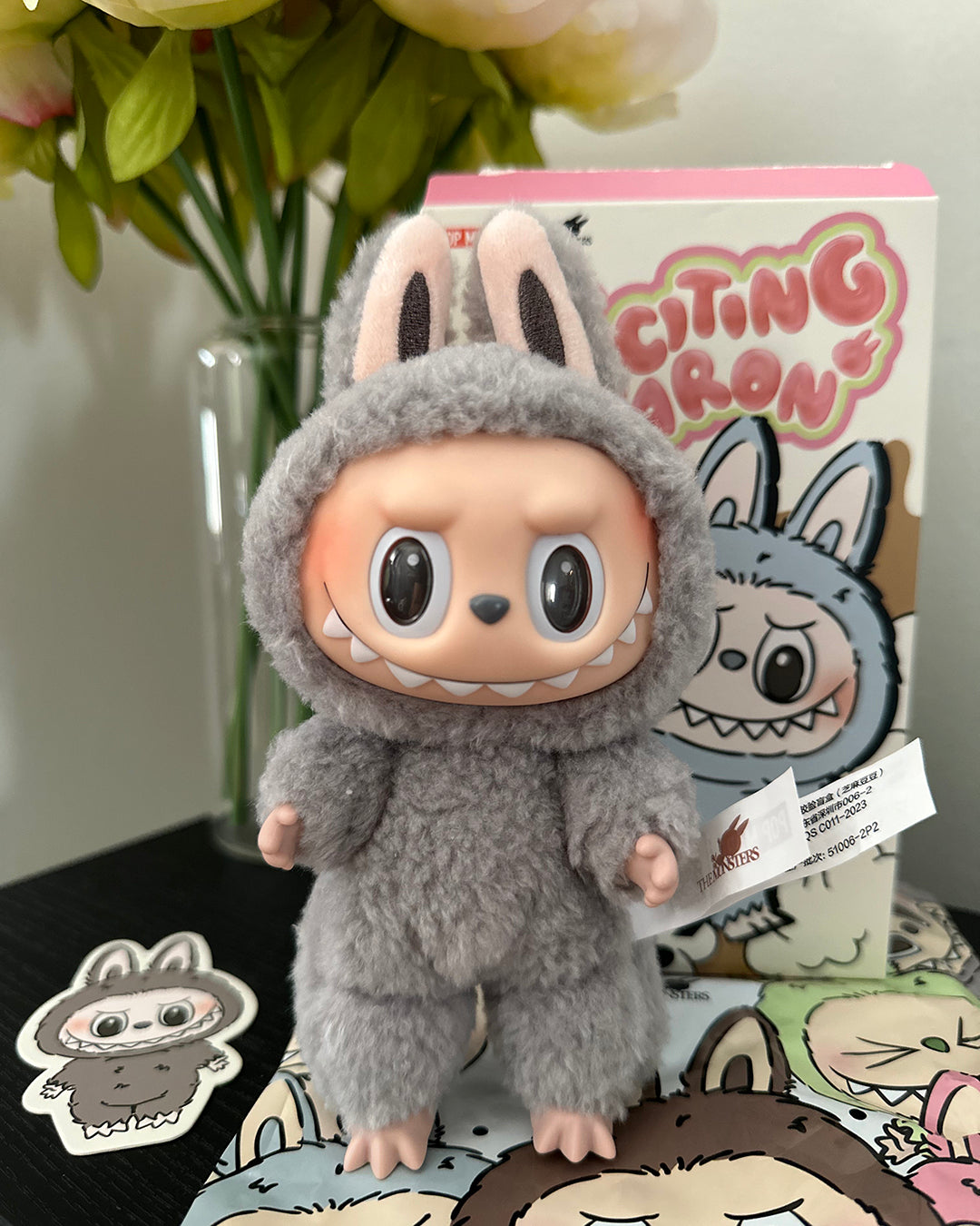 Plush toy in a gray bunny costume with a box labeled 'Citing Aaron' in the background.
