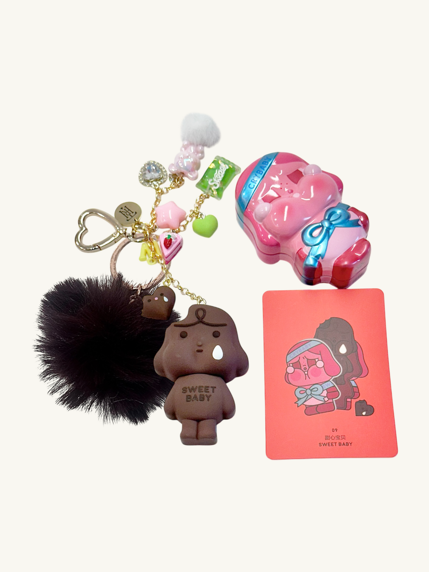 Keychain with plush character, colorful charms, and a card with a similar design on a white background.
