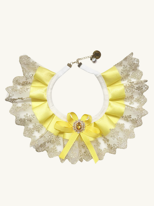 Necklace with yellow ribbons and a brooch on a white background