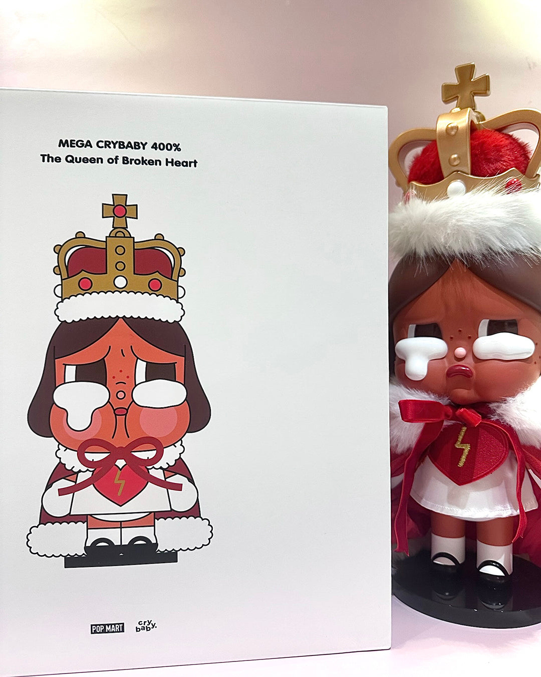 Toy figure with a crown and white outfit next to its packaging