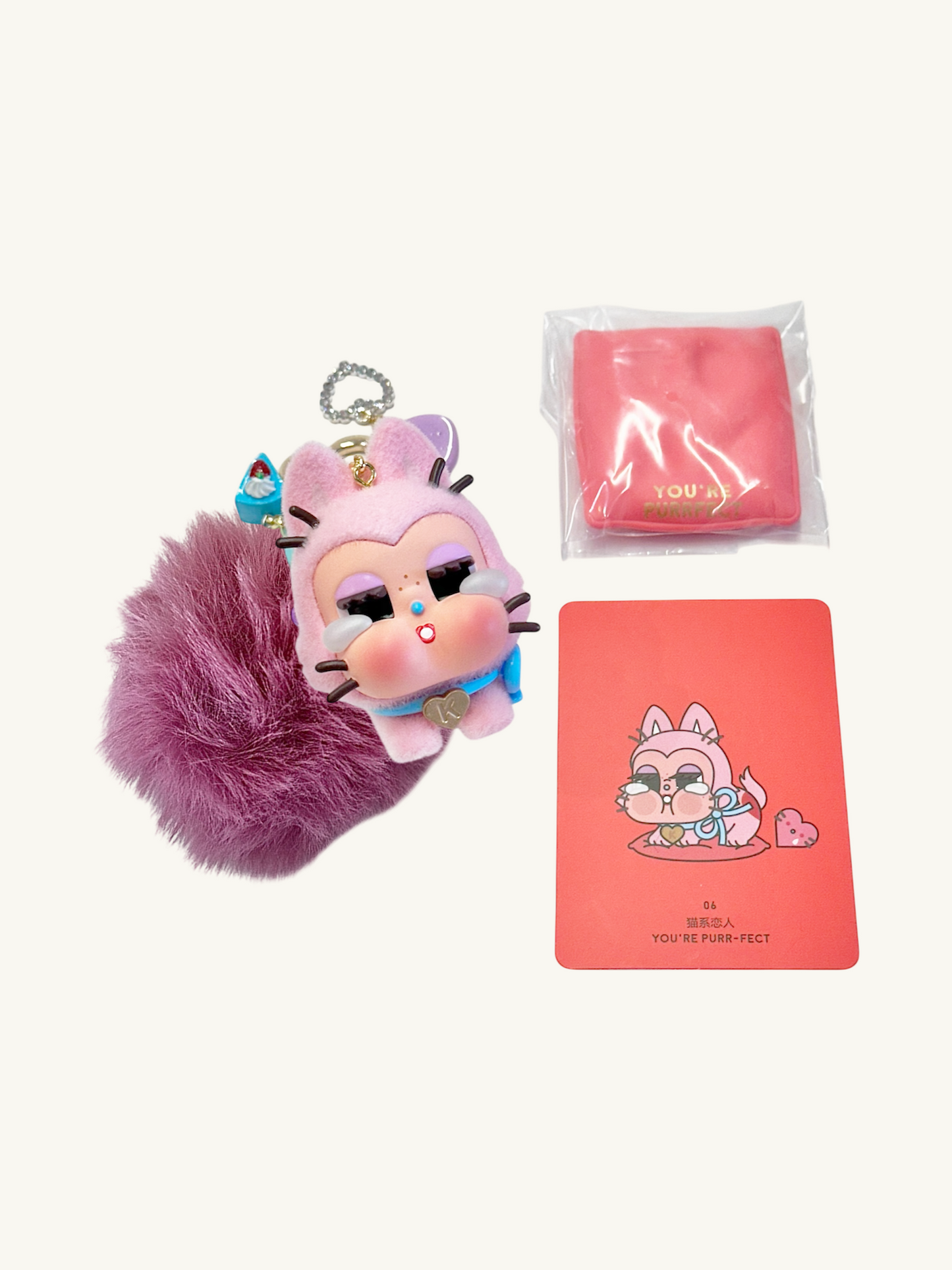 Pink plush keychain with a card and packaging on a white background