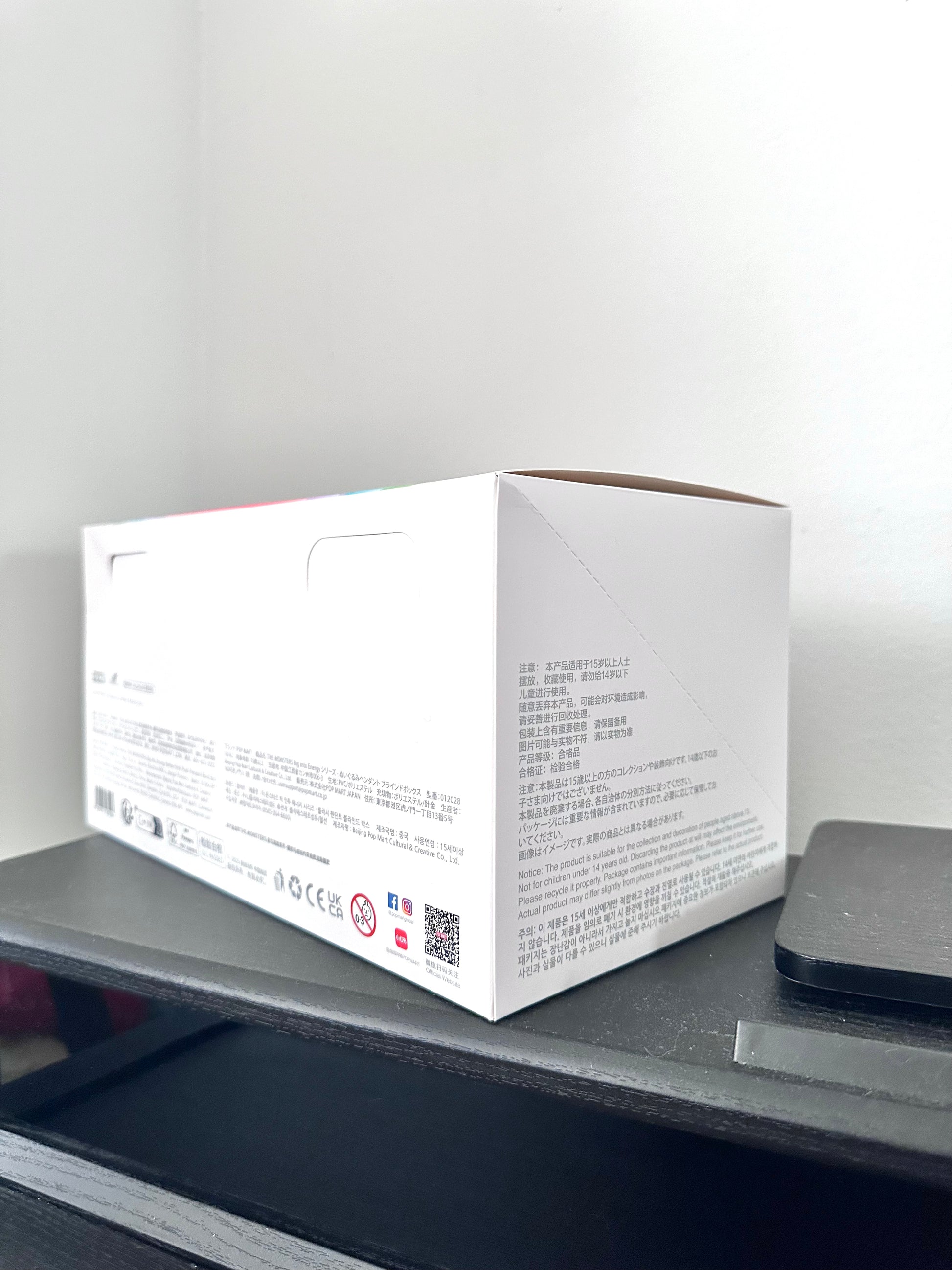 White box with text and QR code on a gray surface