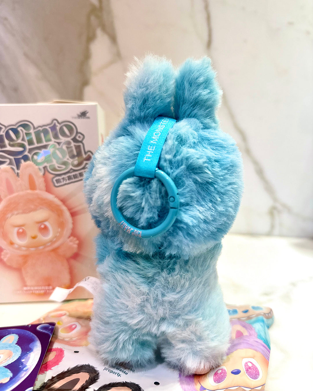 Blue plush toy with a headband on a white surface