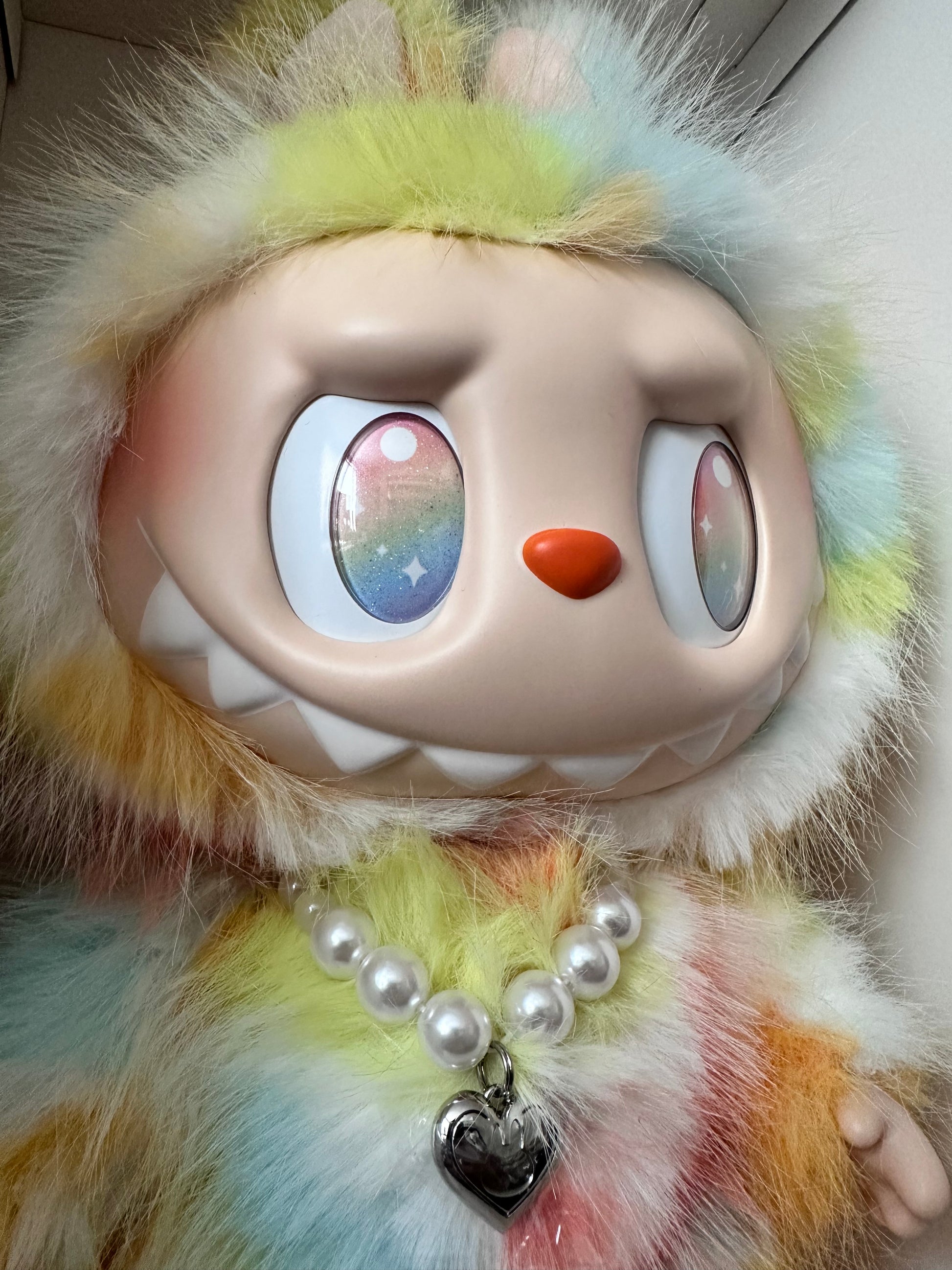 Small electronic device with colorful buttons on a fluffy, multicolored surface.