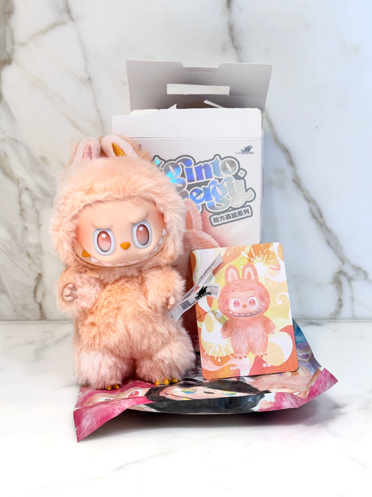 Plush toy with packaging and card on a marble surface