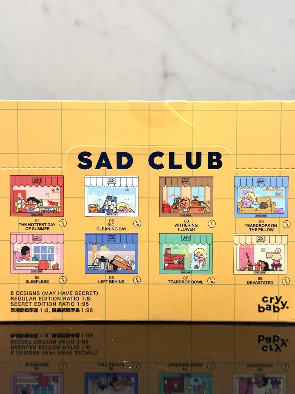 Product packaging for 'Sad Club' with cartoon illustrations on a yellow background