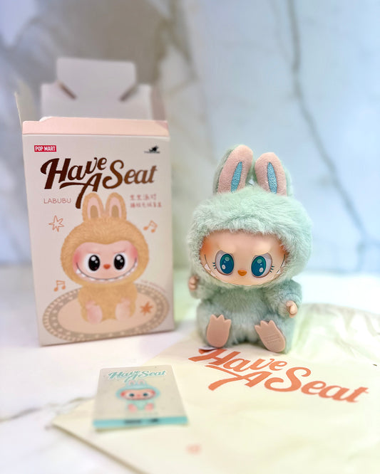 Cute plush toy with packaging labeled 'Have A Seat' on a white background