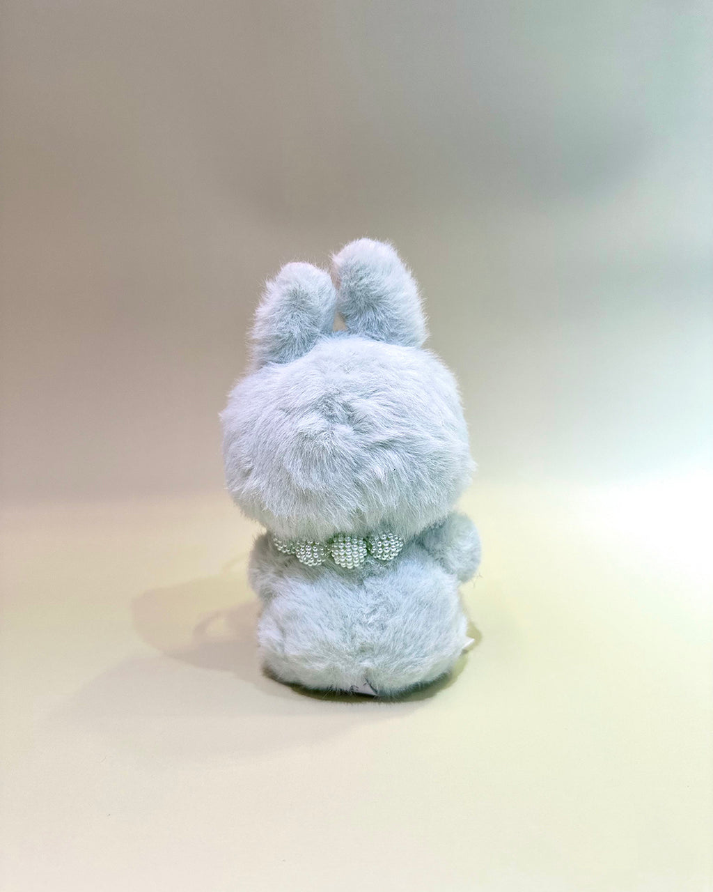 Plush toy with a bow tie on a plain background