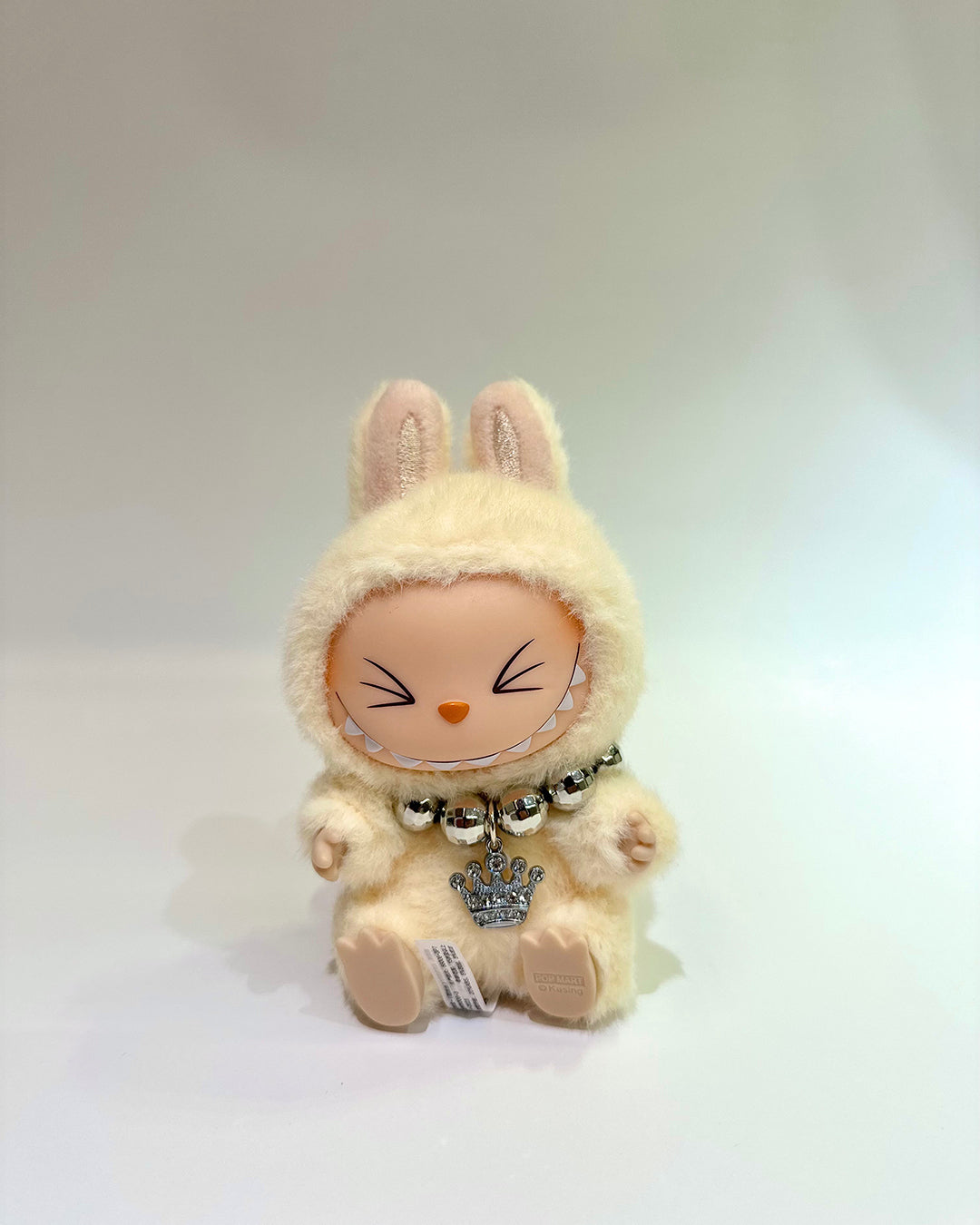 Plush toy with bunny ears and a crown on a white background