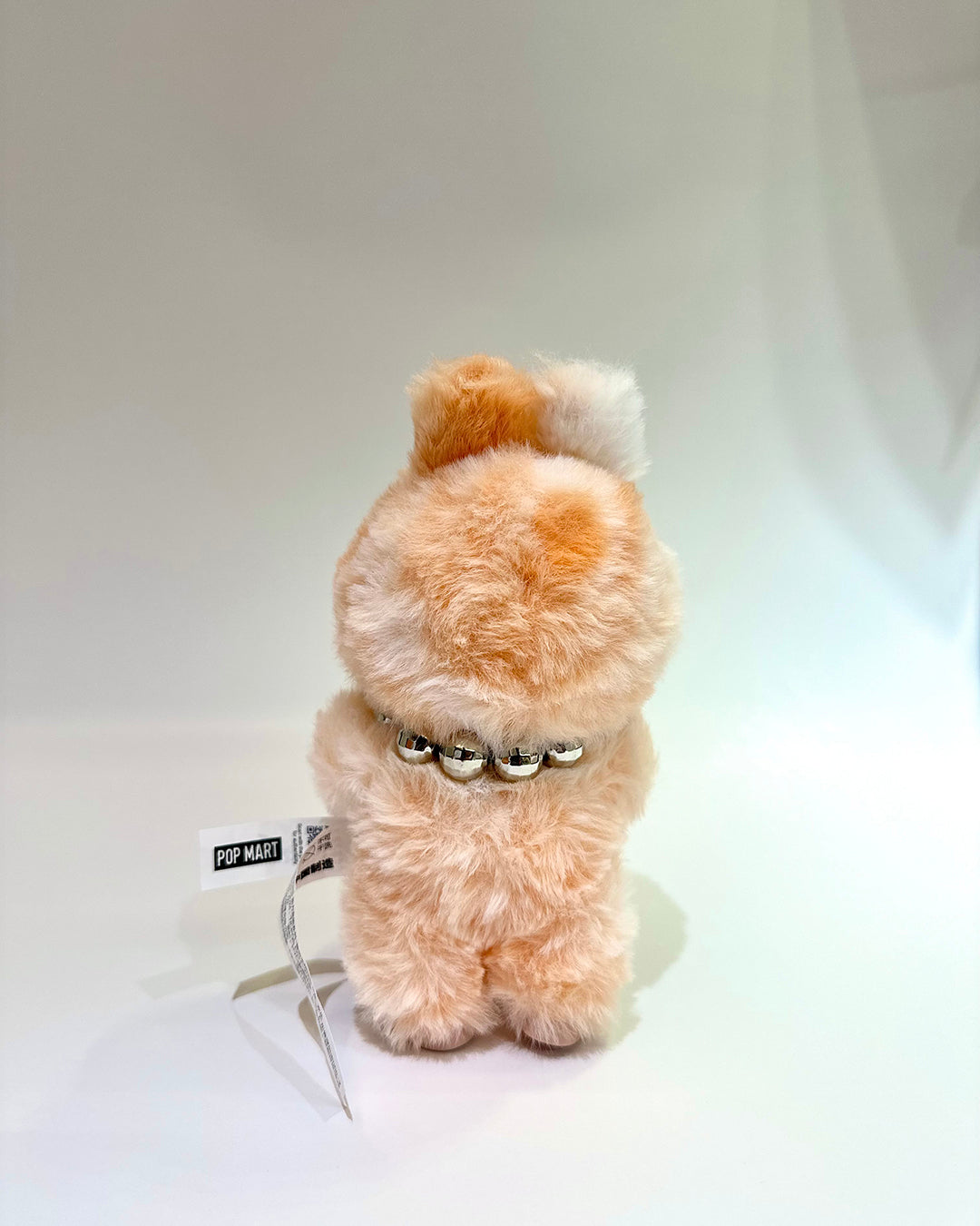 Small plush toy with a collar on a white background