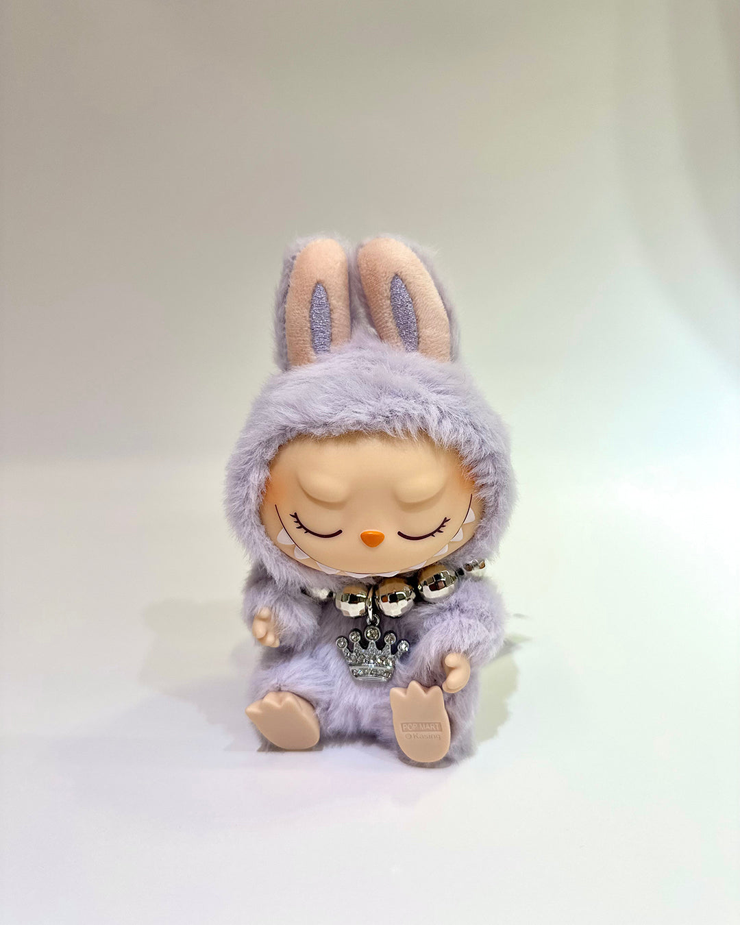 Plush toy with a hood resembling a character on a plain background