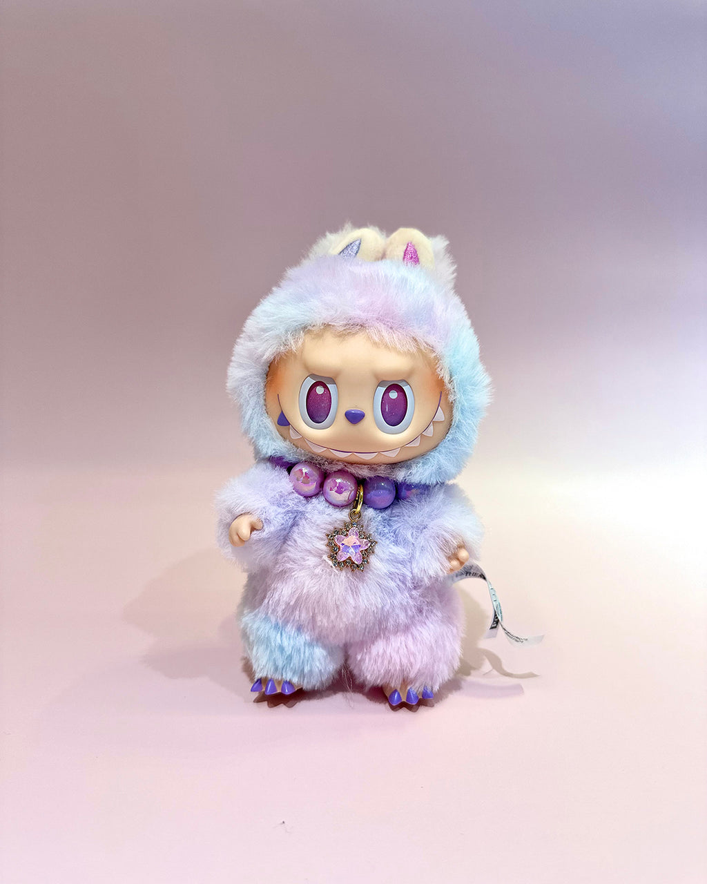 Plush toy with a unicorn design on a plain background