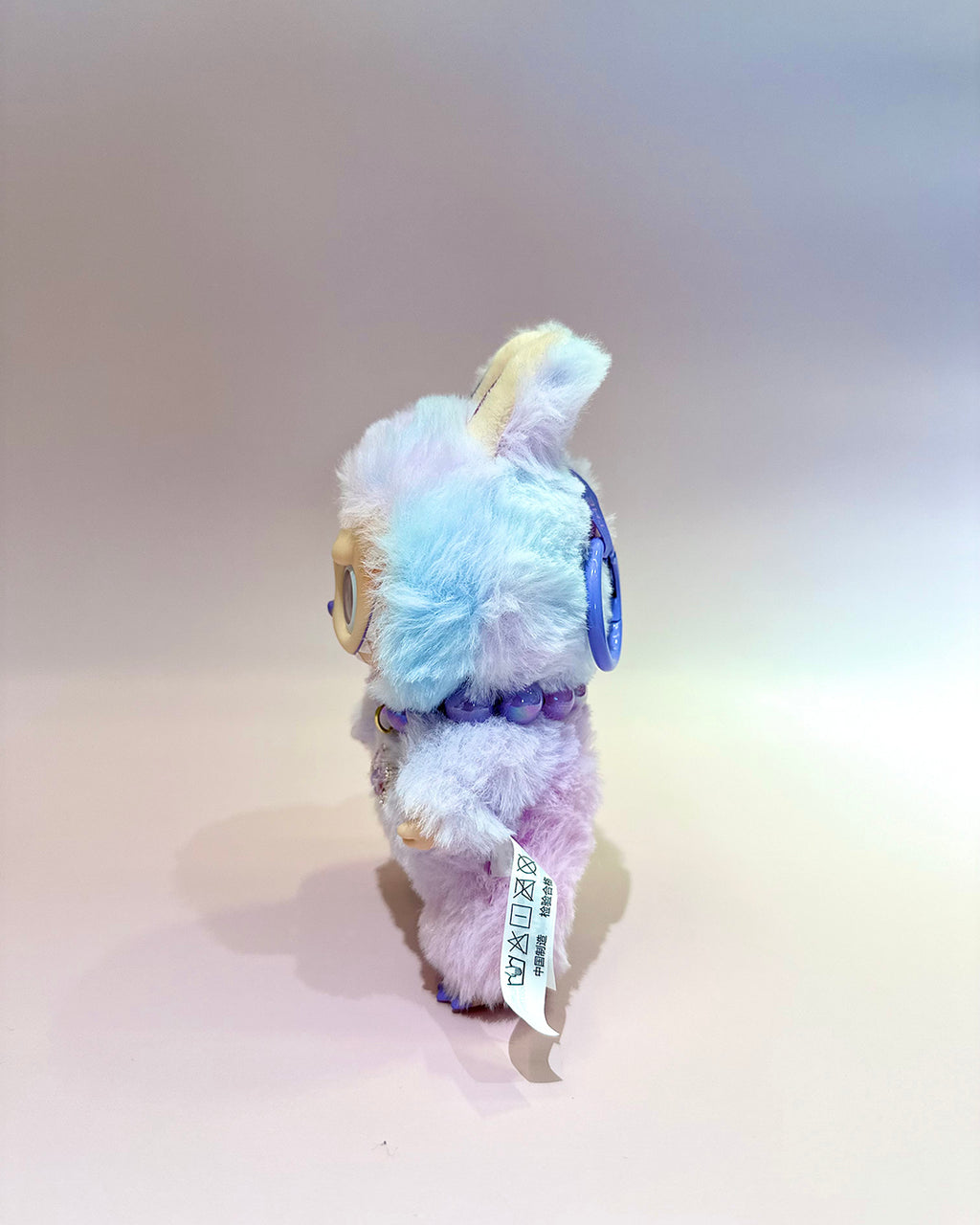 Plush toy with pastel-colored fur on a plain background