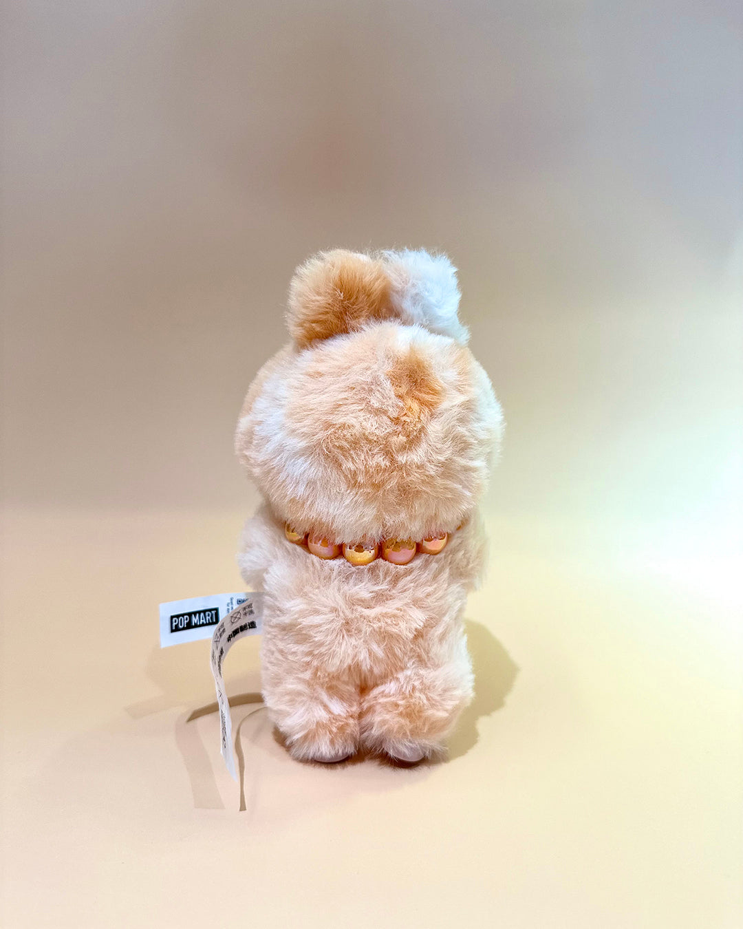 Plush toy with a tag on a beige background