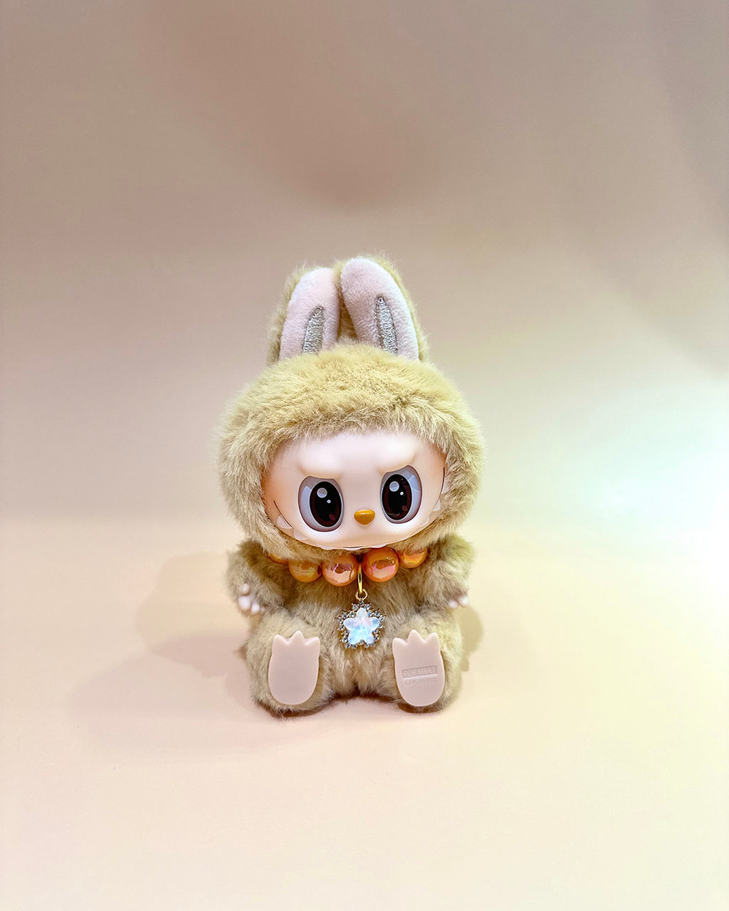 Plush toy with rabbit ears and a fluffy body on a gradient background