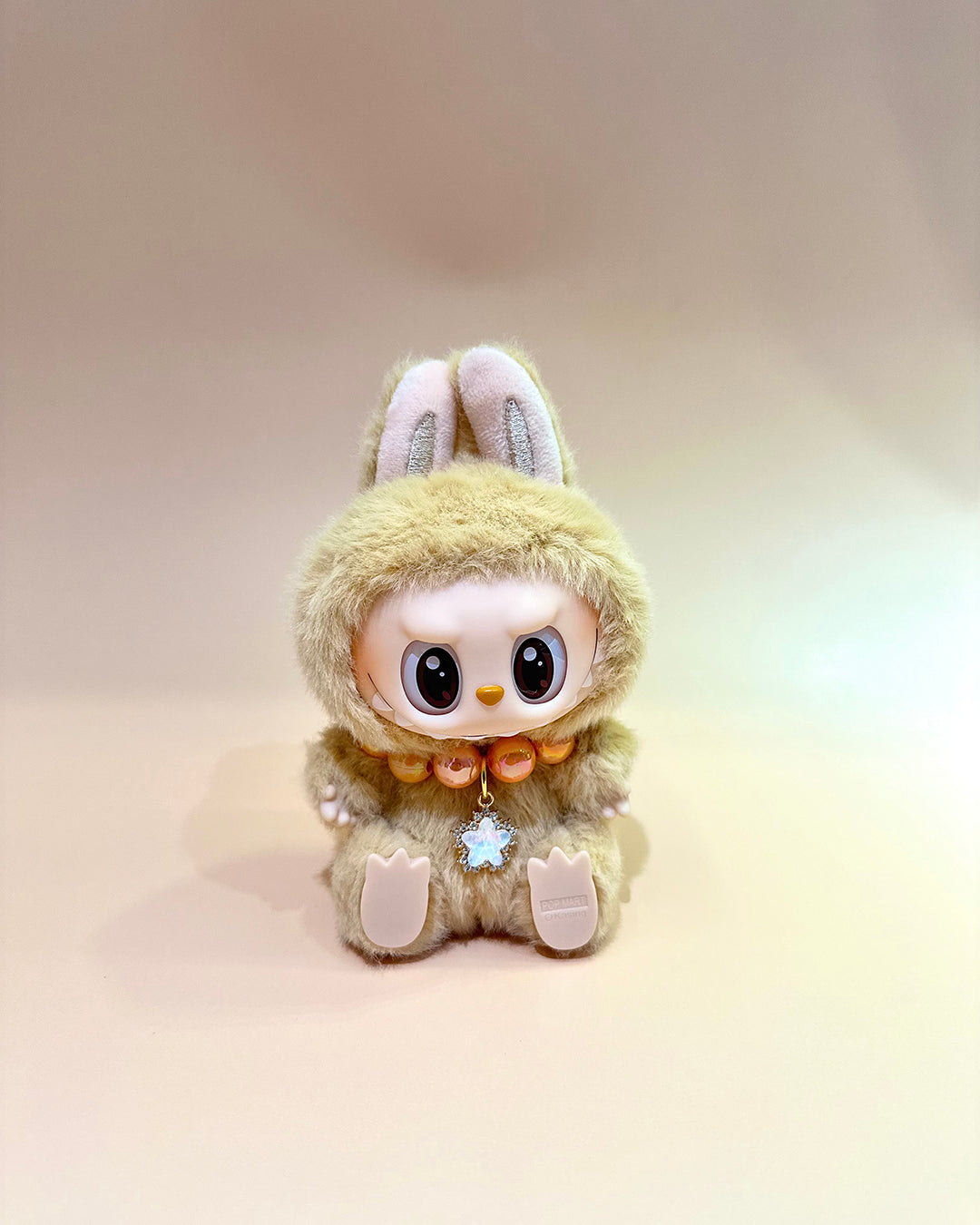 Plush toy with rabbit ears and a fluffy body on a gradient background